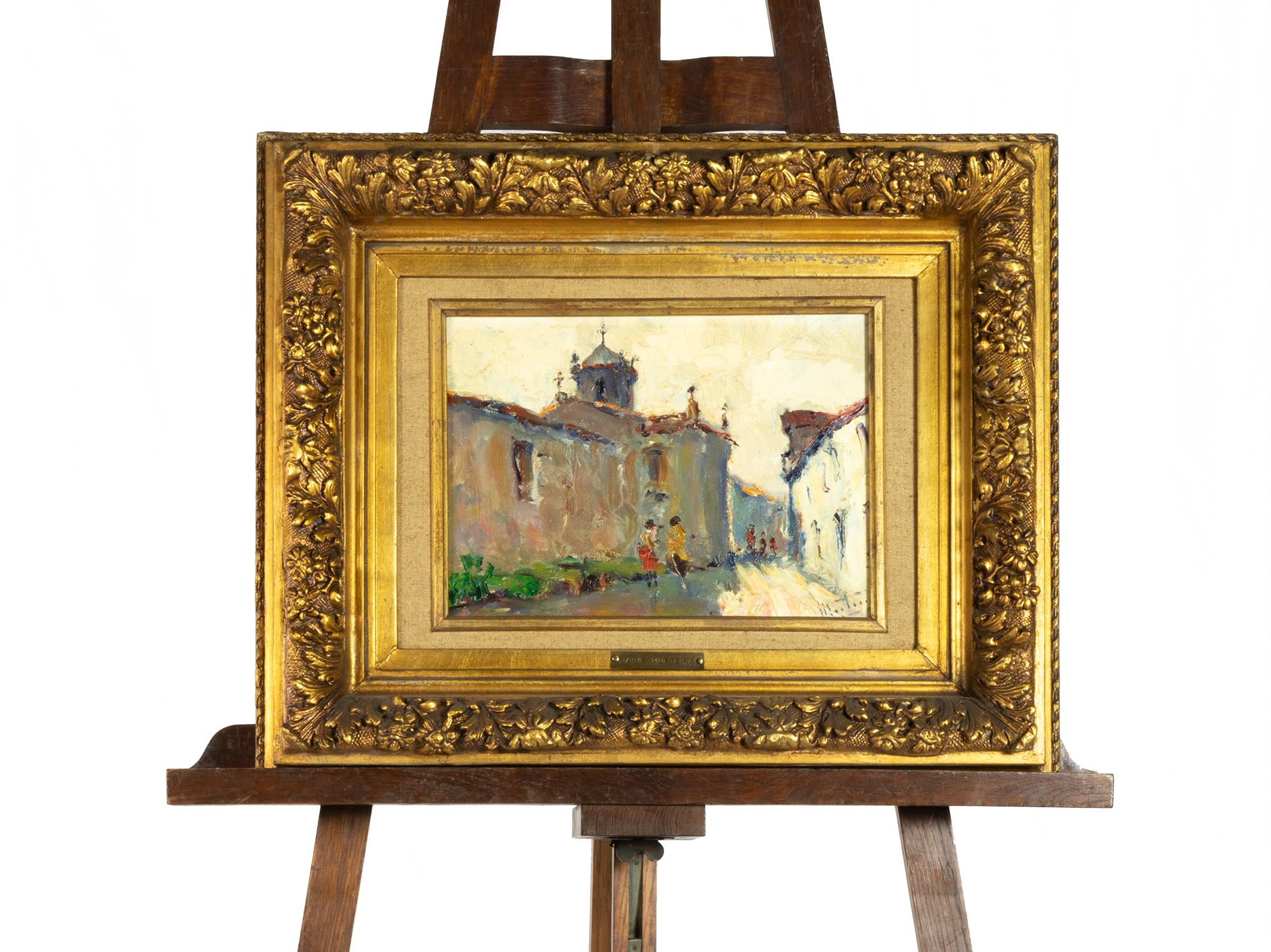 Peinture à l'huile sur platex de Jaime Augusto Murteira (1864-1955), représentant une rue de village éclairée par le soleil, avec une église s'élevant à l'arrière-plan et des personnages passant tranquillement. 
Signée en bas à droite et présentée