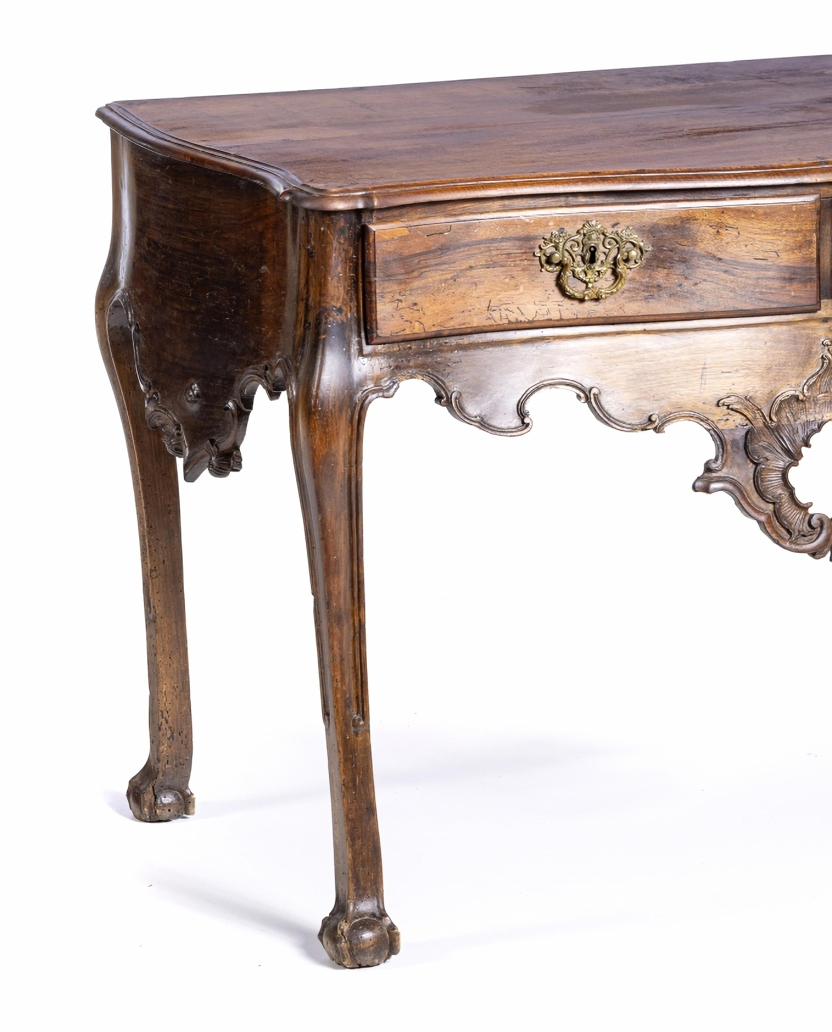 PORTUGUESE  TABLE 18th Century
in walnut wood with a vine top, wavy front with two drawers and cut-out skirts. 
Metal hardware.
Small defects
Dim.: 89 x 120 x 66 cm