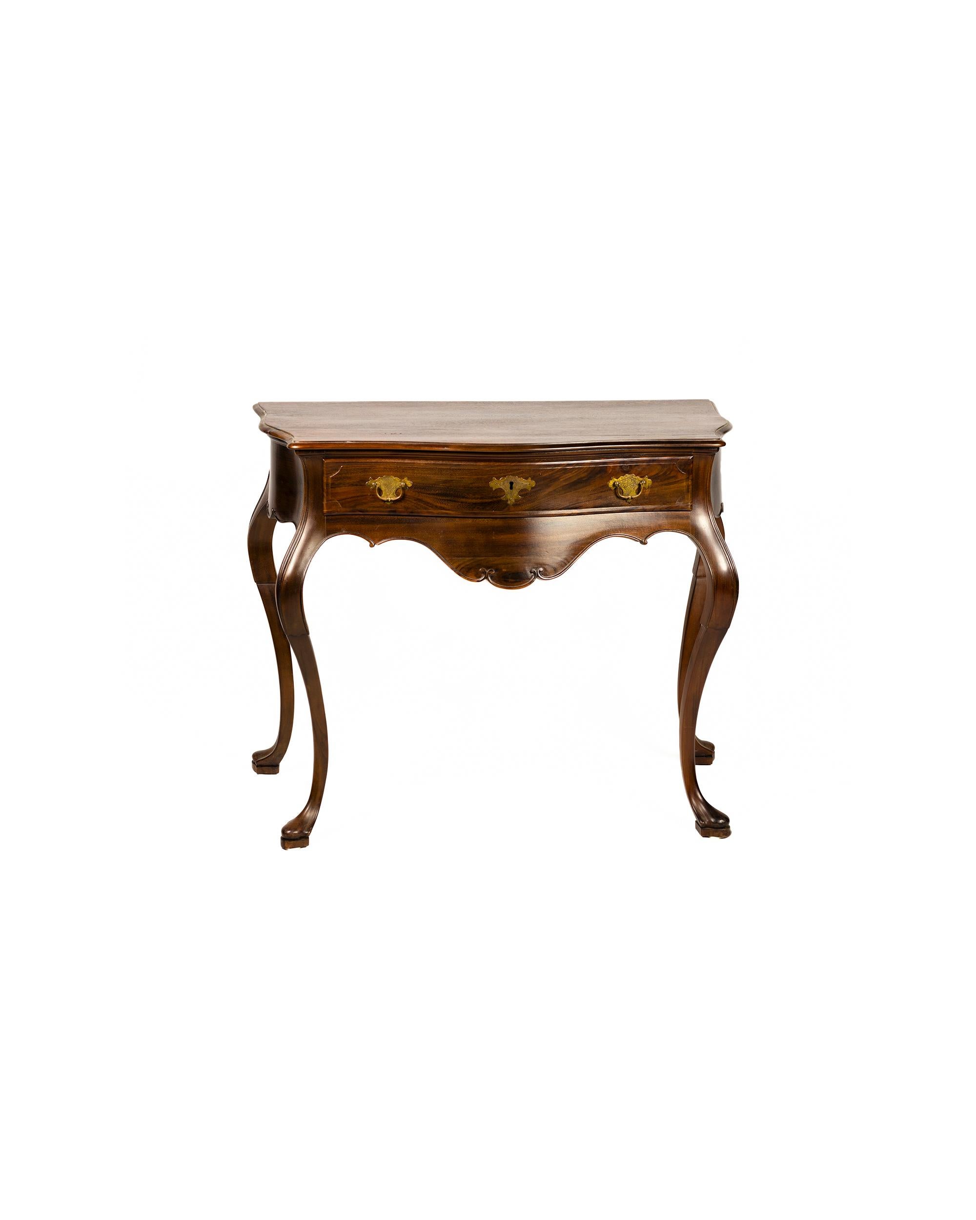 A Portuguese Baroque styled high-end wood single drawer table commode with cut-out top following the lines of the waist and framed by a recess, curved waist, scalloped and notched skirt, curved legs  ending in shoe or pipe feet and brass hardware. 