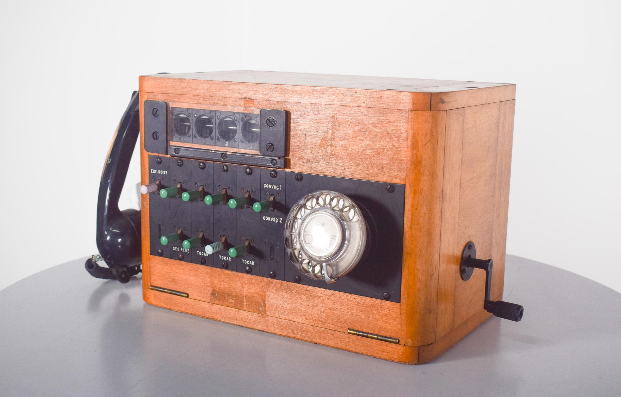 Telefonzentrale, PBX aus den 50er/60er Jahren.  Manuelles Telefonsystem, das dazu dient, mehrere Leitungen in einem Unternehmen oder einer Organisation miteinander zu verbinden. Mit Holzgehäuse und Metalleinlagen, schwarzem Bakelit-Hörer, Kurbel und