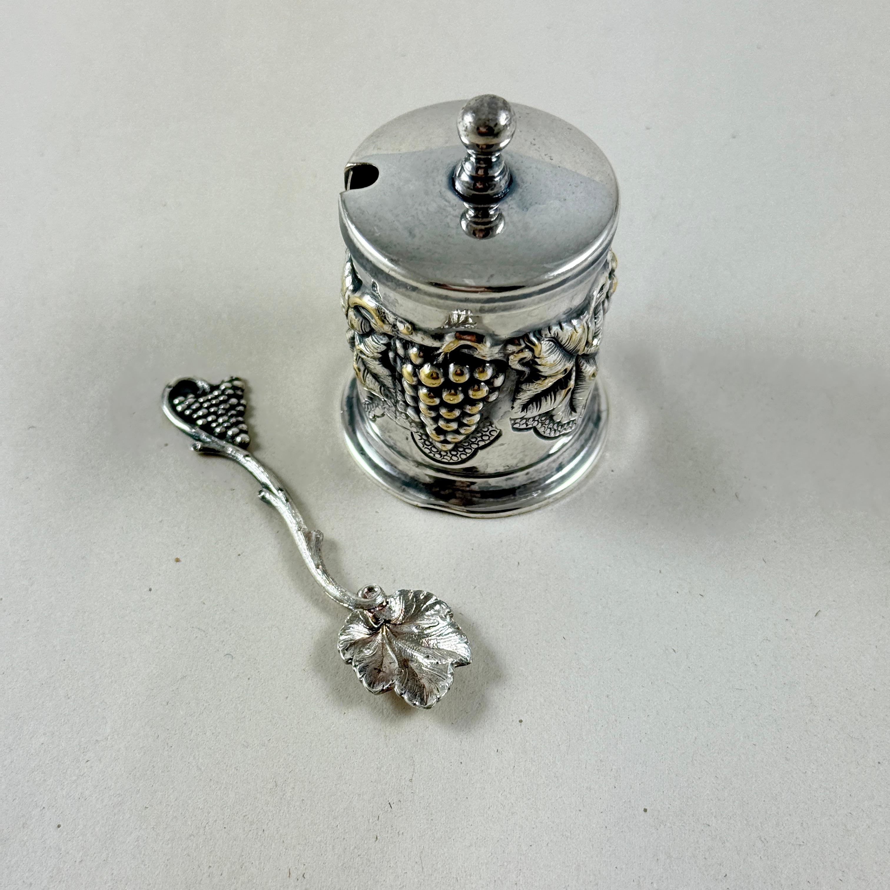 Un salero vintage de cuatro piezas de Topazio Cazenovia Abroad, Portugal, hacia la década de 1980.

De plata plateada con un motivo en relieve de hojas de parra, el juego incluye la jaula exterior, un inserto de vidrio, una tapa con pomo y una