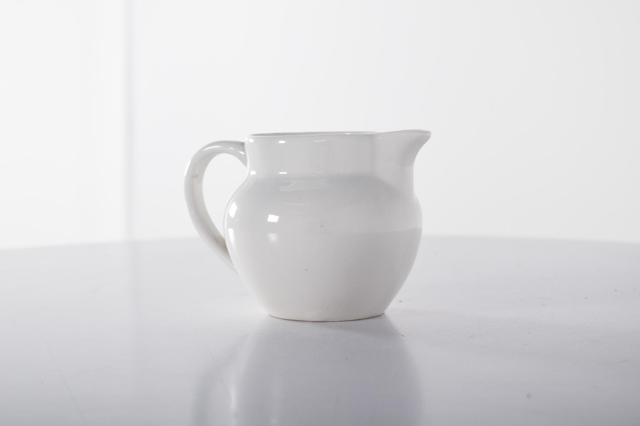 Teiera in porcellana bianca. Il design è semplice e funzionale. Forma arrotondata, con una ciotola ampia e un'apertura dolcemente ondulata, che riflette la tradizione della ceramica utilitaria portoghese. L'ampio manico, ben integrato nella