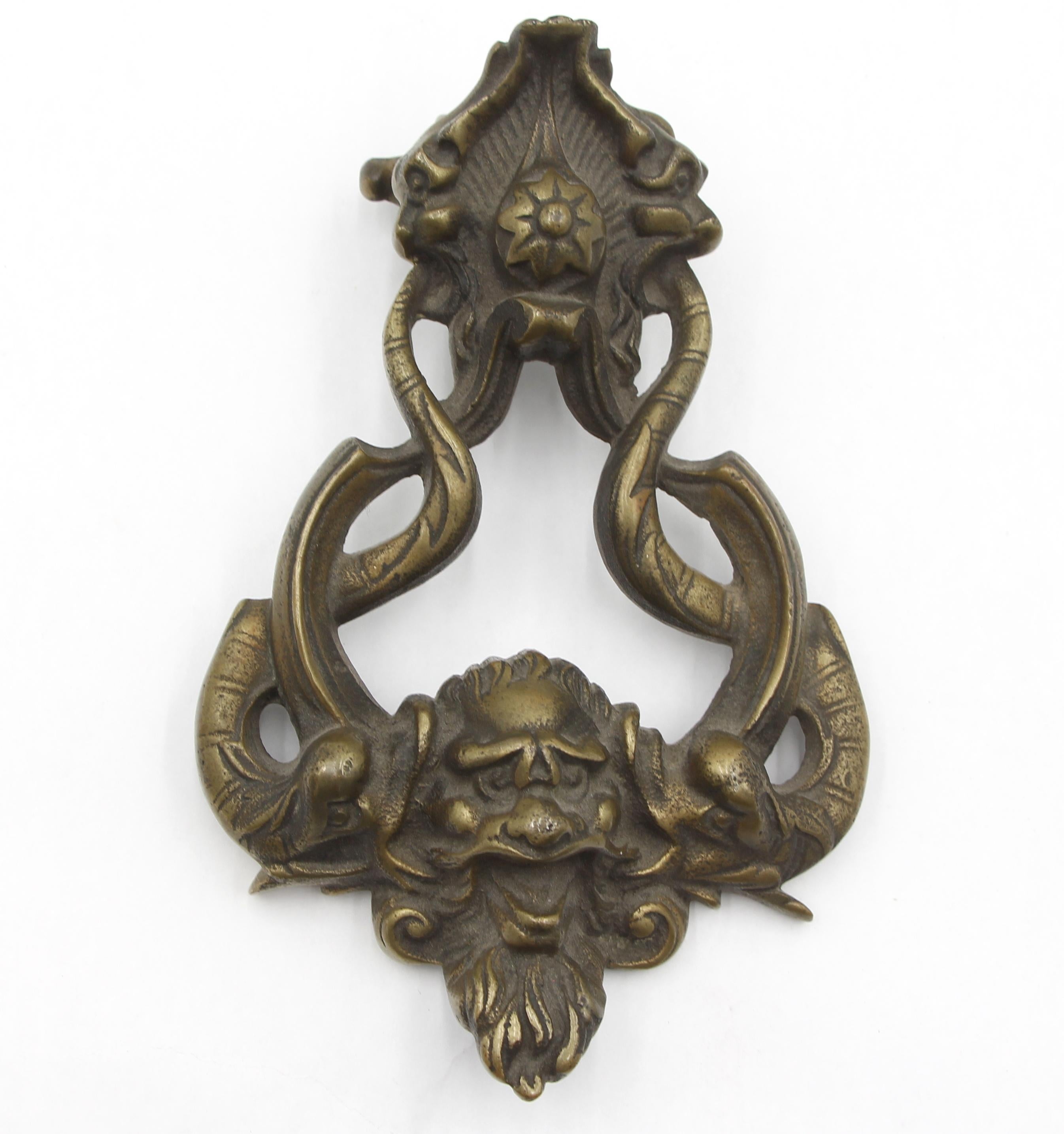 Brass door knocker with strike plate featuring the mythical sea creature, Poseidon, with a prominent face and flowing beard. Good condition with surface wear from prior use. Stamped Made in England. One available. Please note, this item is located