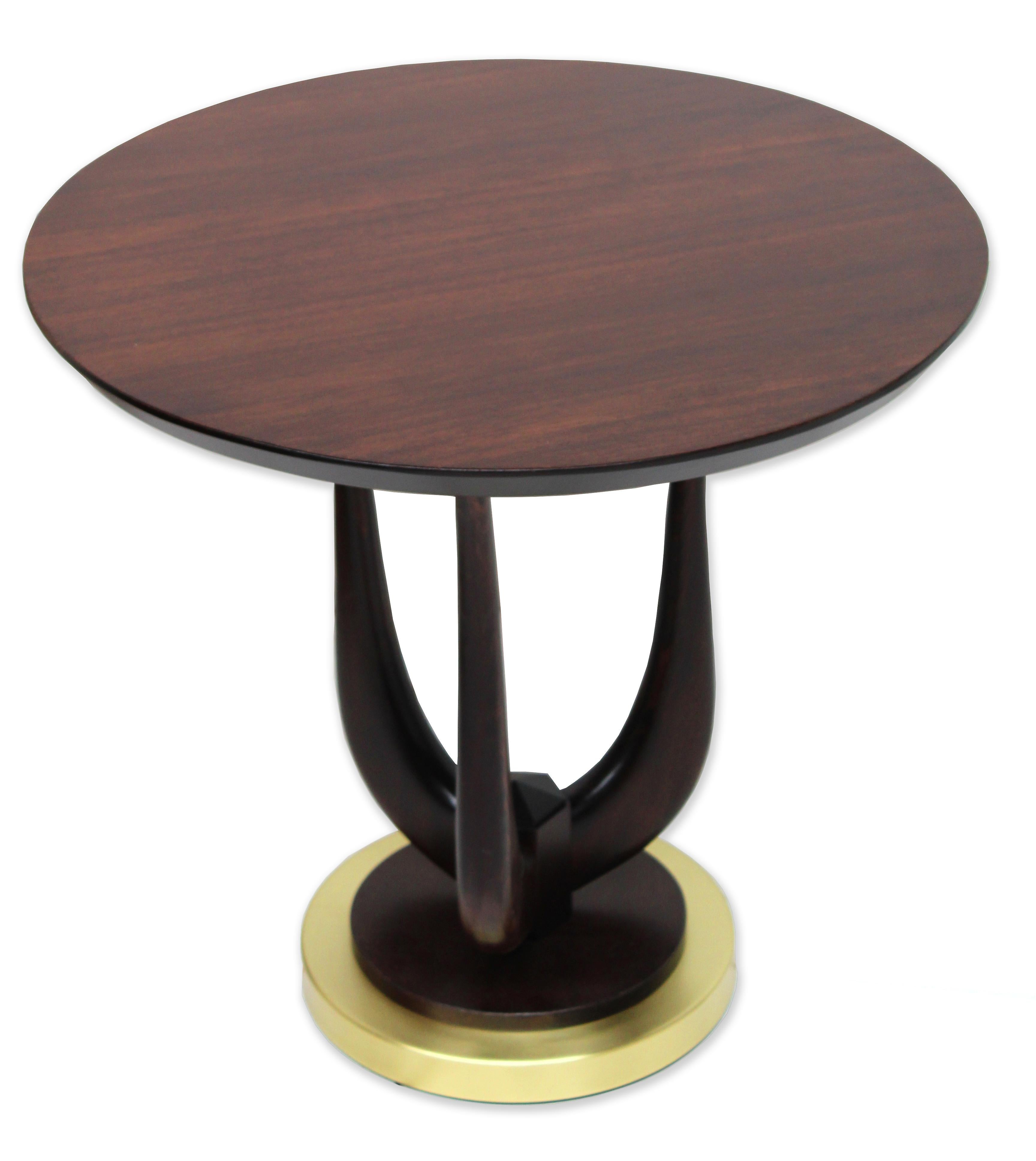 Crafted with meticulous care, this hand-made masterpiece features a satin brass base that forms the foundation for three sinuous legs in solid wood, branching out like a trident to elegantly cradle the wooden veneered top.

The juxtaposition of the