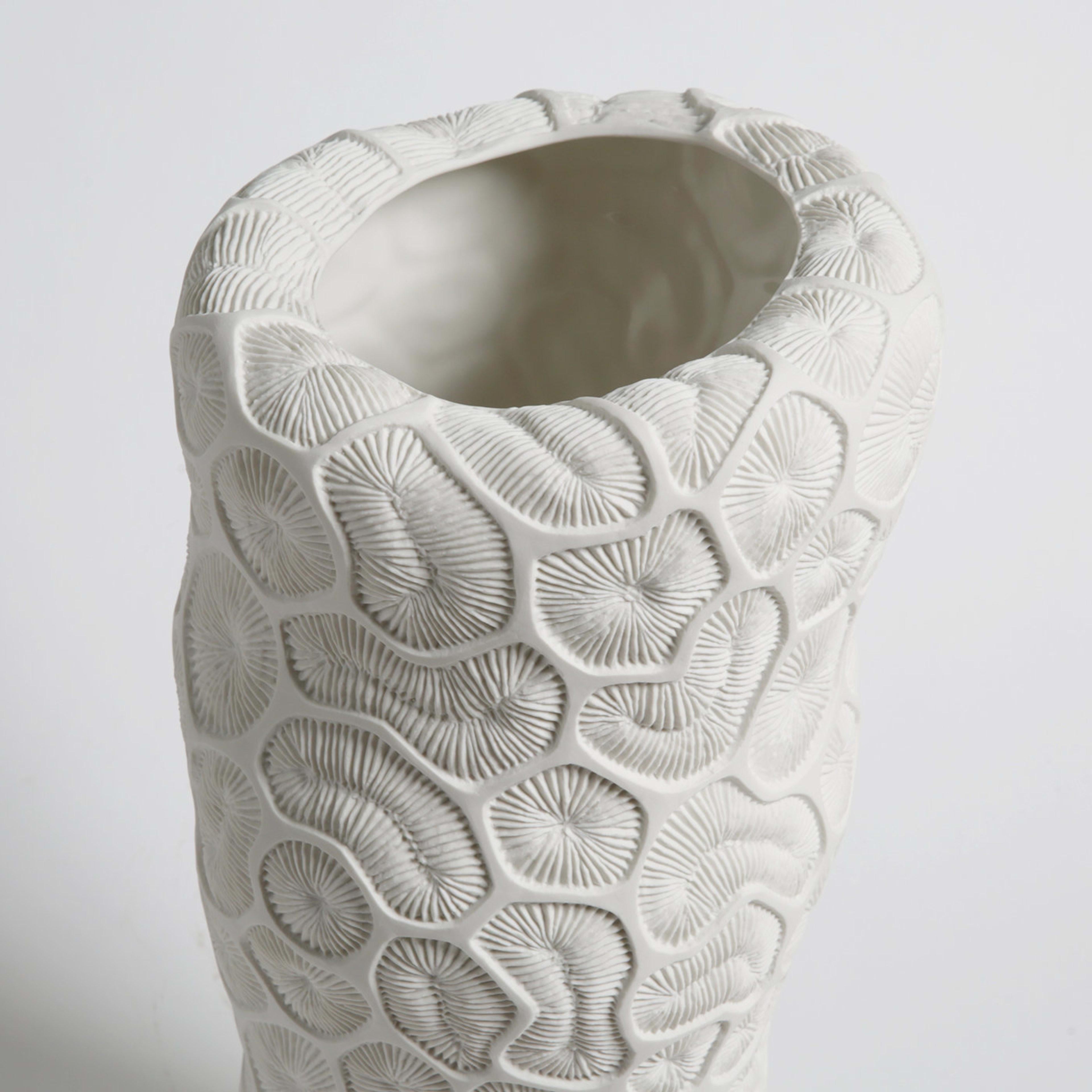 Fossils of madrepore inspire the minute texture decorating this striking vase of the Fossilia collection. A meticulously crafted mold and the use of precious unglazed porcelain, or 