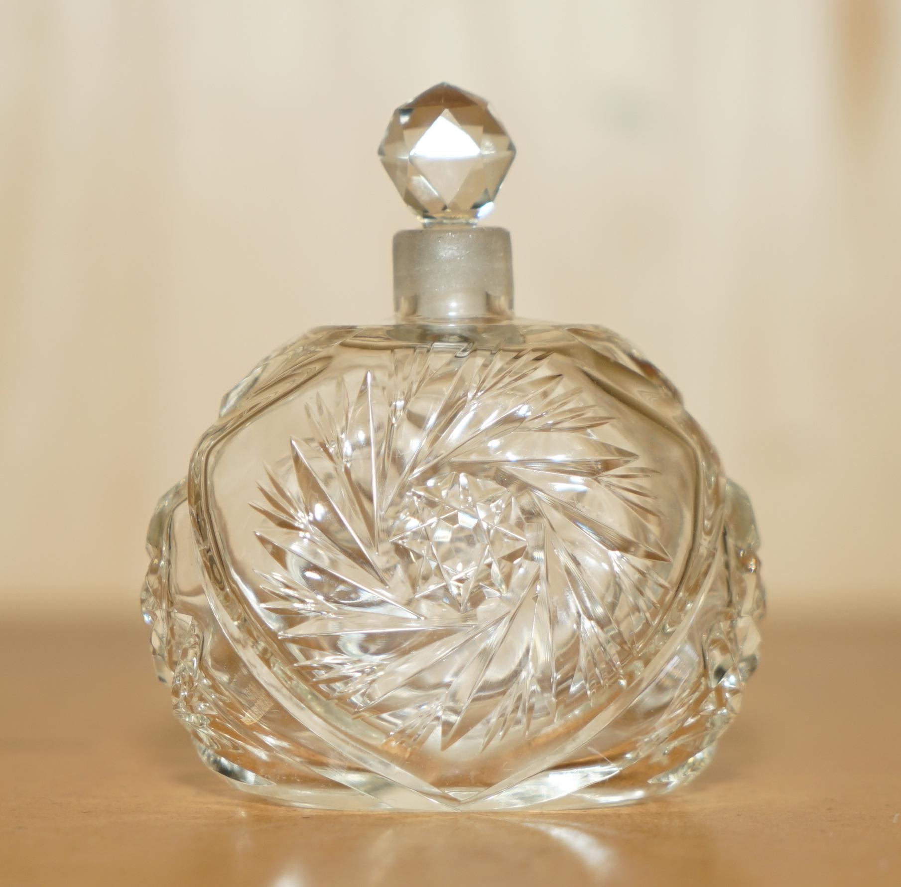 Royal House Antiques

The House Antiques a le plaisir d'offrir à la vente ce superbe flacon de parfum en cristal en verre taillé de style Art Déco, datant d'environ 1920.

Le corps principal et le bouchon sont en cristal de verre fortement taillé,