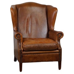 Positively lived-in sheepskin leather wing chair with pleasant seating comfort