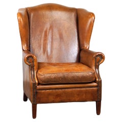 Positively lived-in sheepskin leather wing chair with pleasant seating comfort