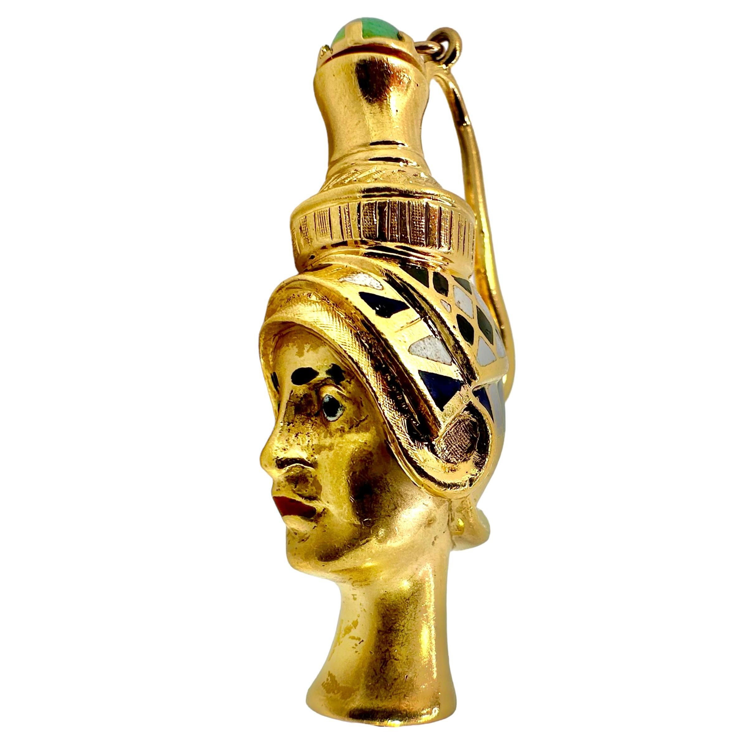 Cette amulette de parfum italienne du milieu du XXe siècle, très imaginative et artistiquement travaillée, se présente sous la forme d'une tête égyptienne antique. La magnifique caricature d'une grande prêtresse ou d'un pharaon est ornée d'émaux