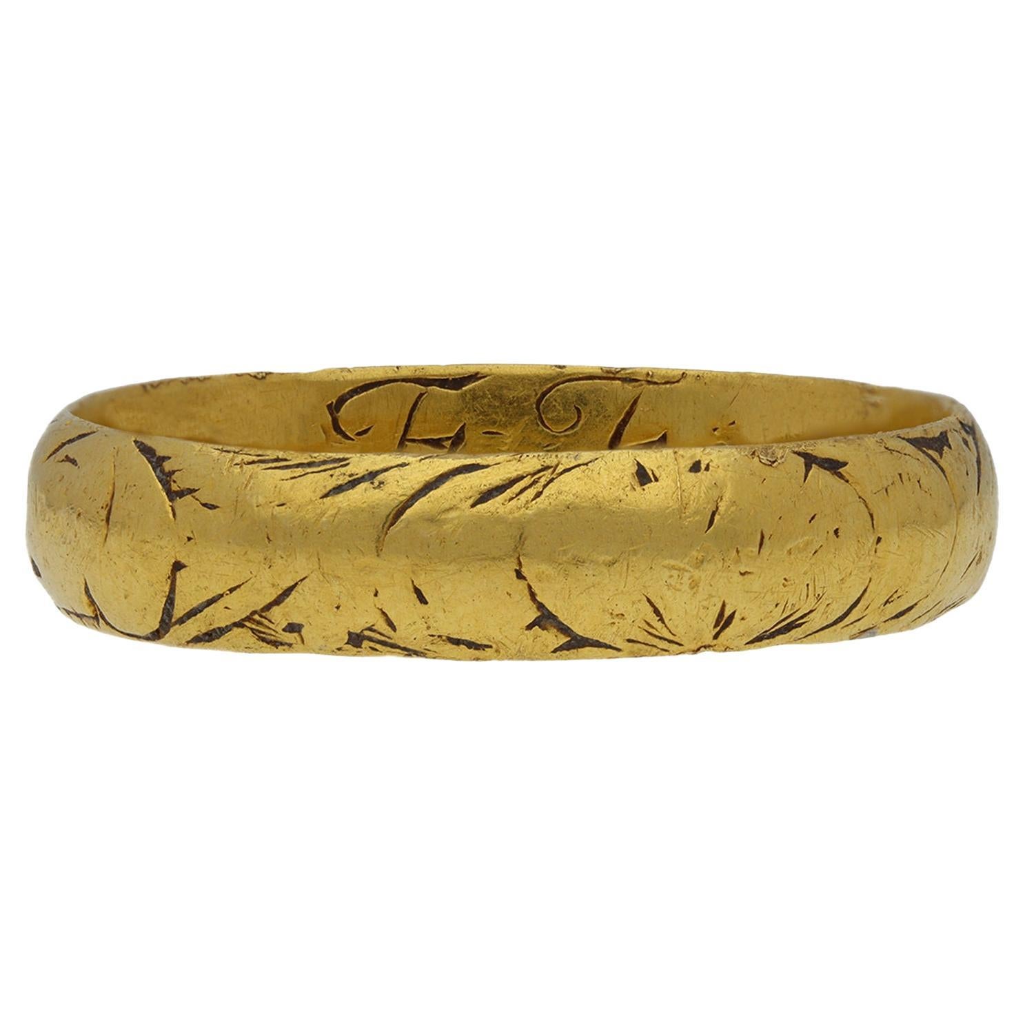 Post-Medieval enamel mourning ring. A smoothly conforming half round band, featuring an engraved skull design and repeating scroll motif with remnants of black enamel, the interior engraved ‘E Fearne, obt, 17 Apr 1706, aet 41’, and maker’s mark.