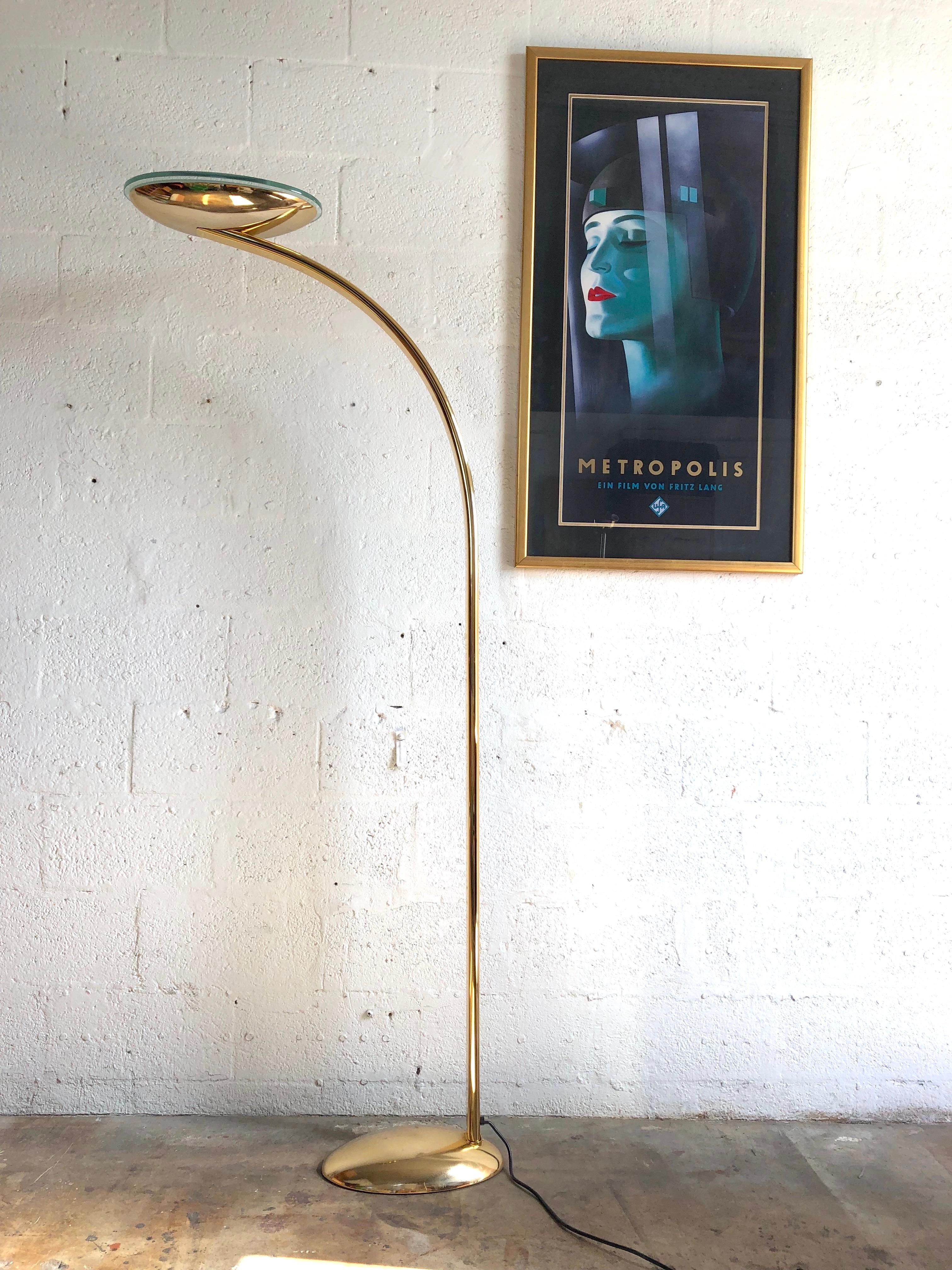 Post Modern Art Deco revival halogen brass arched torchiere floor lamp. Circa mid-1980s
Features a stunning futuristic Art Deco Inspired Design, a reasonable large size, a reverse oval dome with teal tempered glass trims, a flat brass pleated