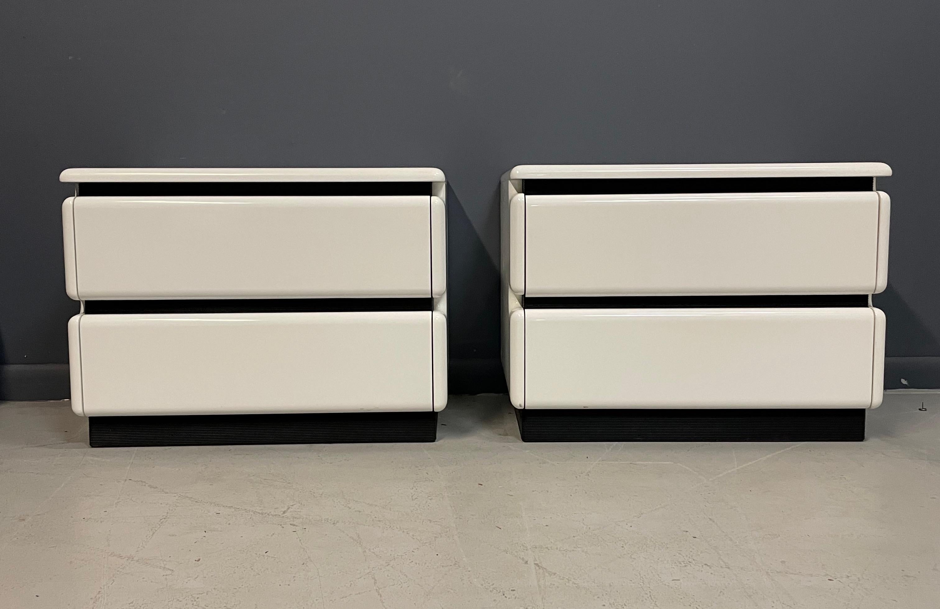 These great nightstands were created in Canada by Rougier. They have a very futuristic design and are a lacquered white with ribbed black rubber accents and have two generous drawers with hidden pulls.

Please see our other listings for the matching