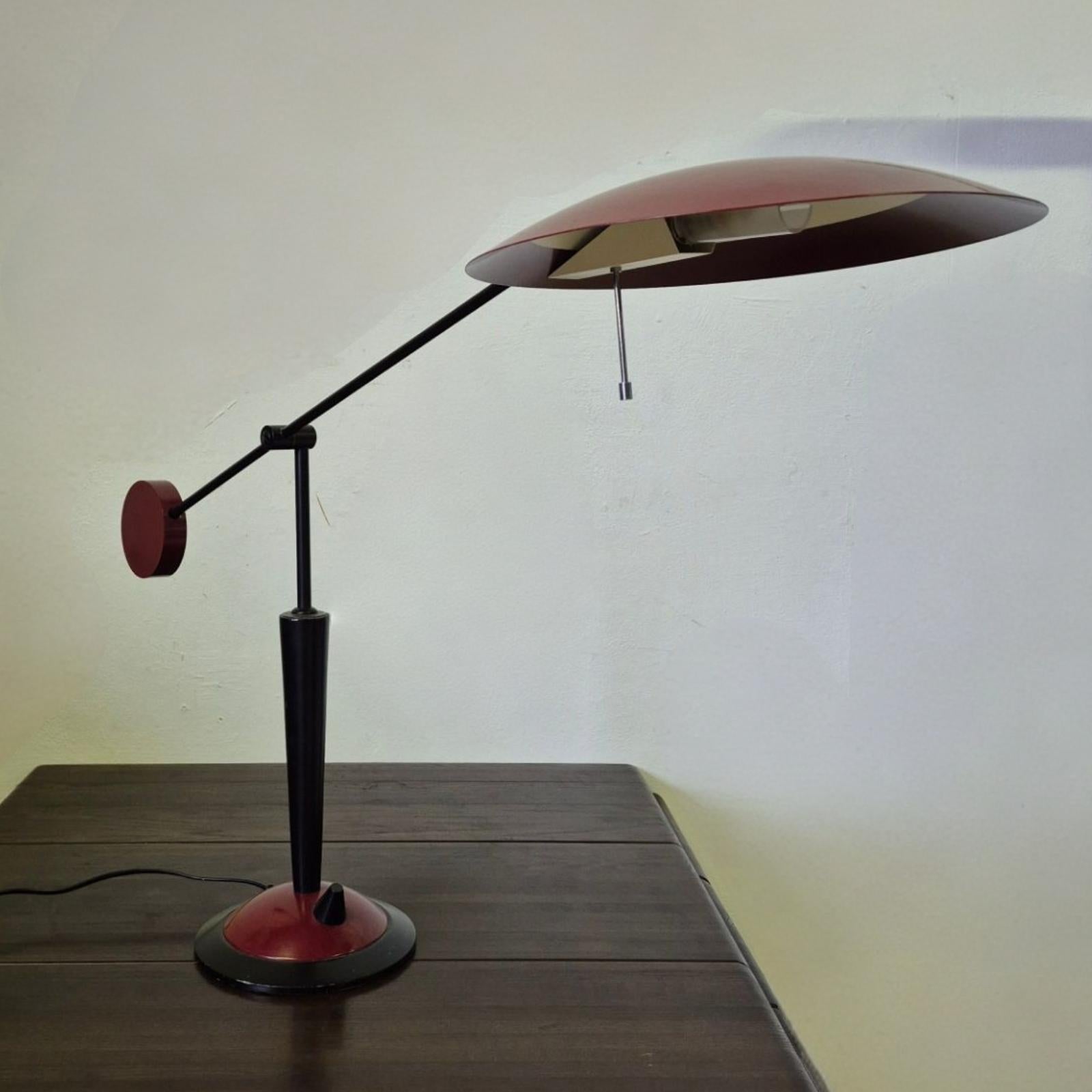 Post modern design desk lamp. Made by Dutch company Herda in the 1980s. Made from wood and metal. I has a halogen bulb that is dimmable by a turn knob on the base. 
The lamp in full upright position measures 113cm. the shade measures 32cm in