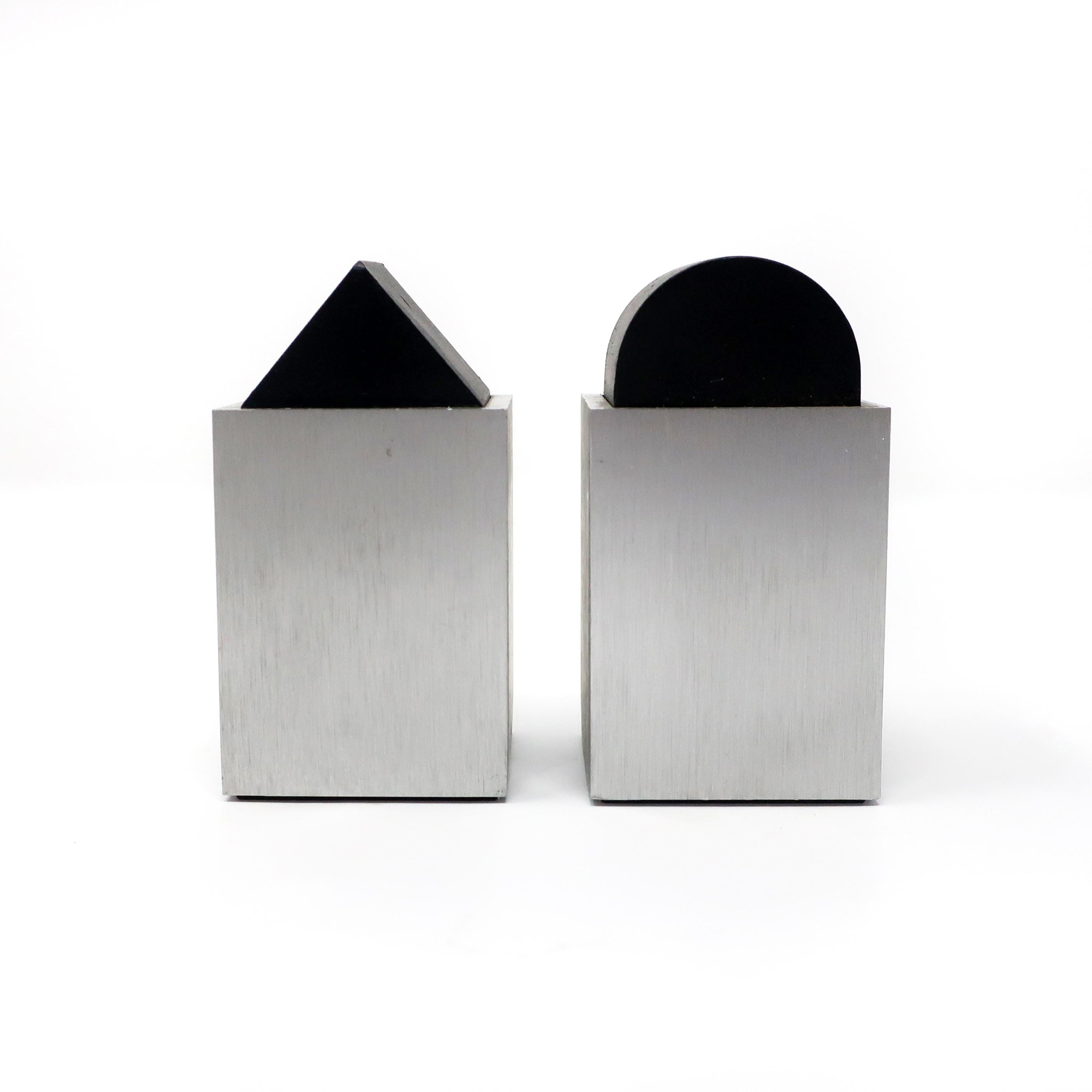 A lovely pair of Postmodern, Memphis inspired salt and pepper shakers by David Tisdale for Elika. Both are silver anodized aluminum while one has a rounded top and one has a triangle top. In excellent vintage condition with wear consistent with age
