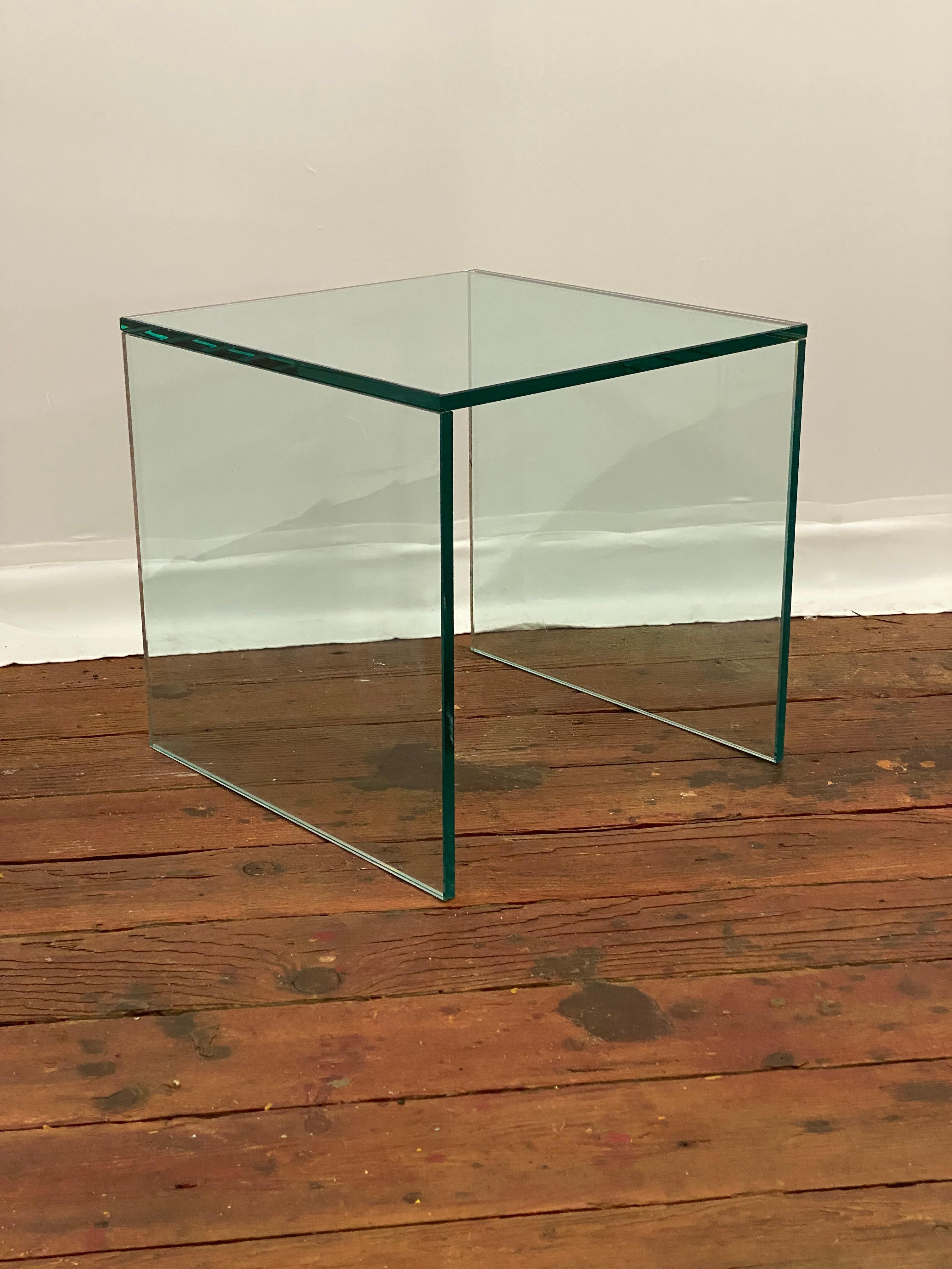 Post modern minimalist bevel edge glass end table. The simplicity of form and function with a three piece slab construction. A good older example with the signature green edge color with nicely polished and beveled edges. Circa 1980-1990.

Good