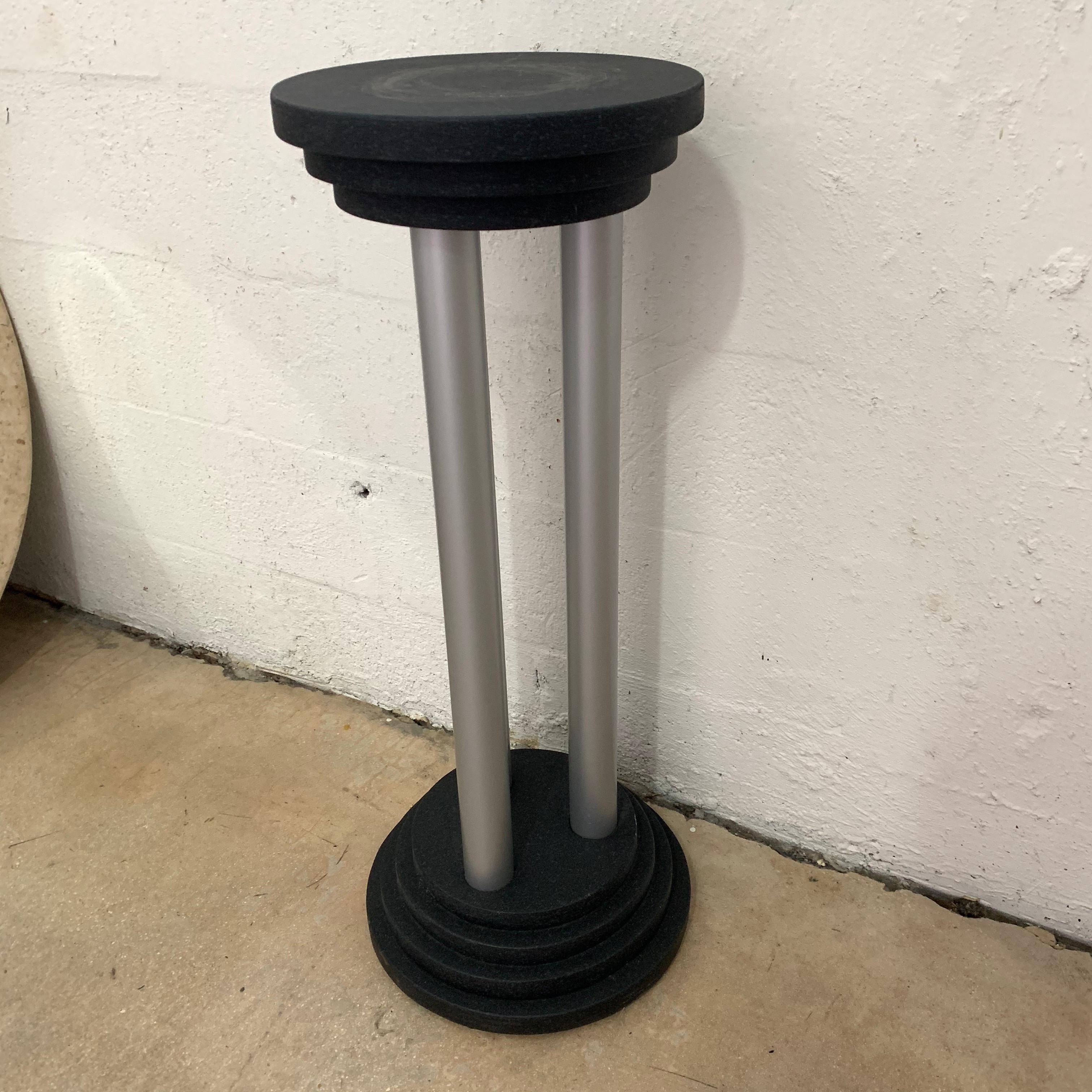 Postmodern pedestal or plant stand rendered in stacked wood base and top, painted in a black and grey matte fleck tone paint, suspended between three grey painted wood cylinder columns, Italy, 1990s.