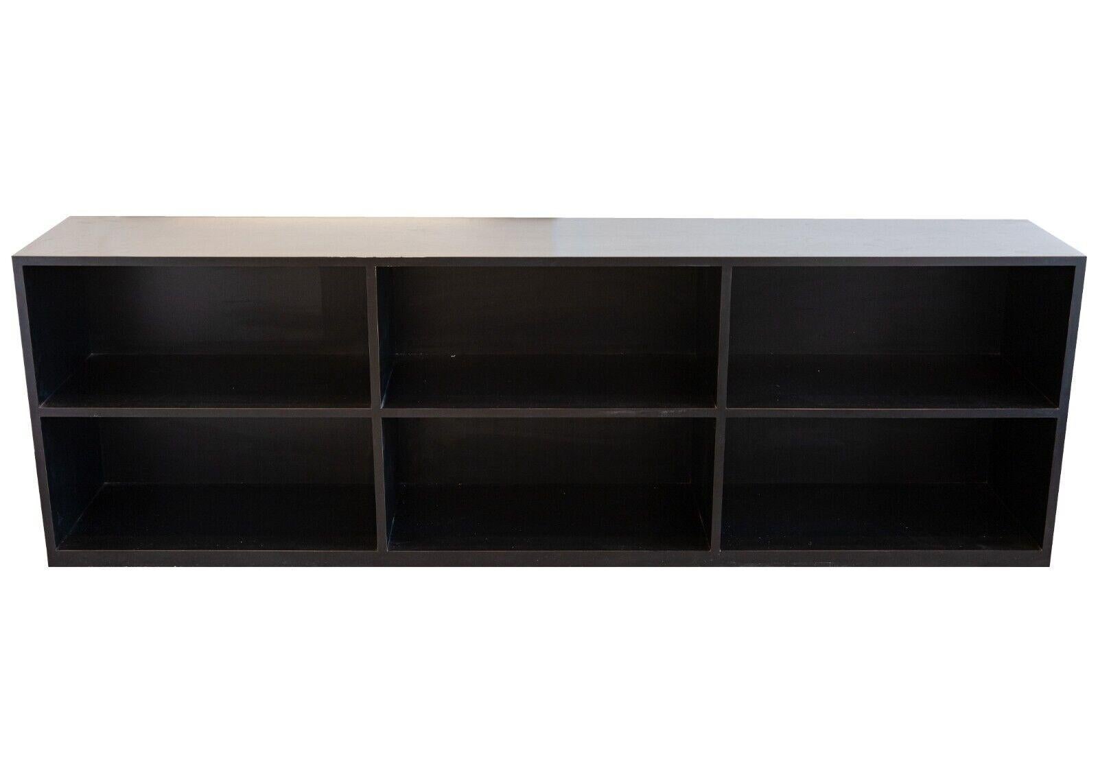 A large black shelving unit. This versatile shelving unit is a great addition to any room. Its very dark black coloring makes it usable in a great variety of spaces and styles. It contains 6 shelves and a large flat top. This piece is in very good