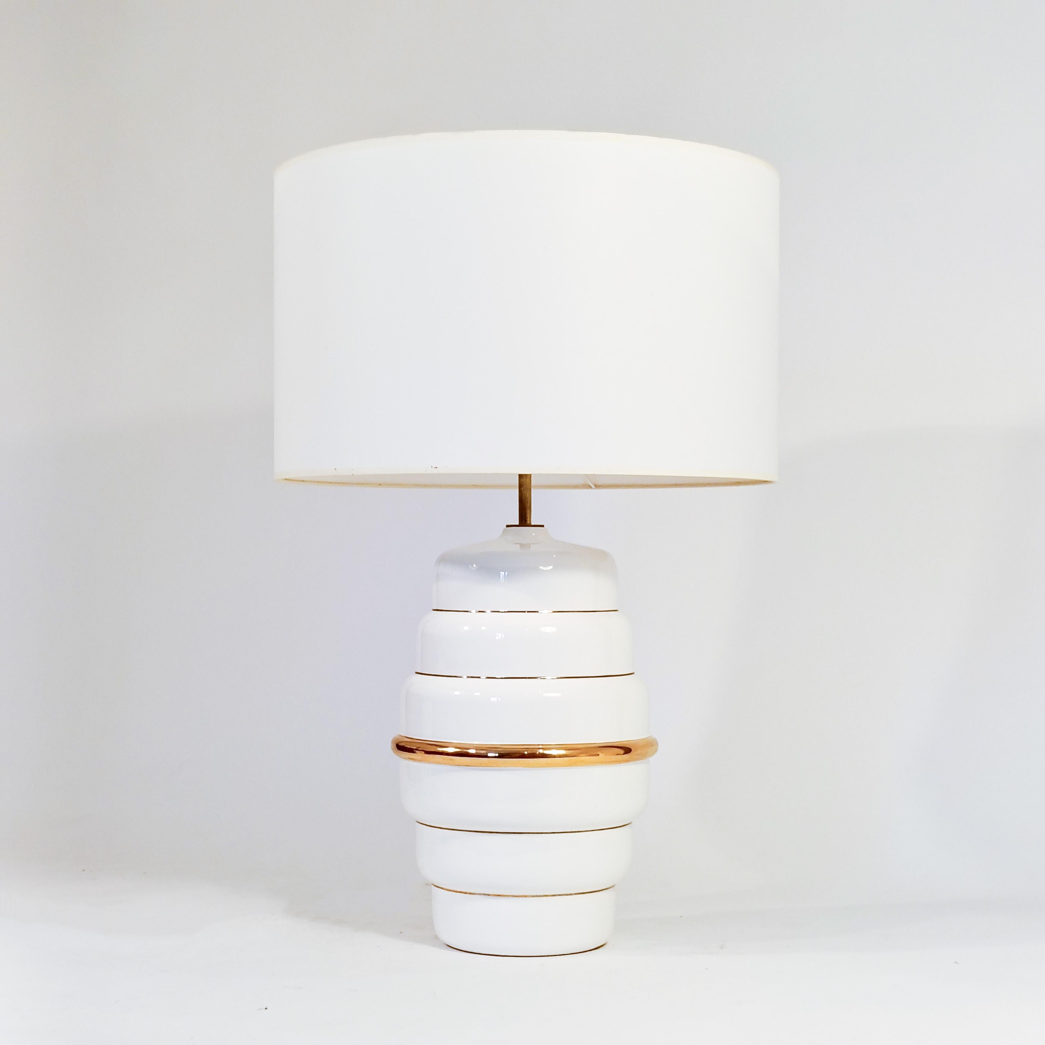 Cubist and Post-Modern style ceramic table lamp, Italy, 1980s. It has the shape of a tibor or white glazed ceramic vase with golden hand-painted trims. The structure of the top is made of brass. Very timeless design and Post-Modern aesthetic, with a