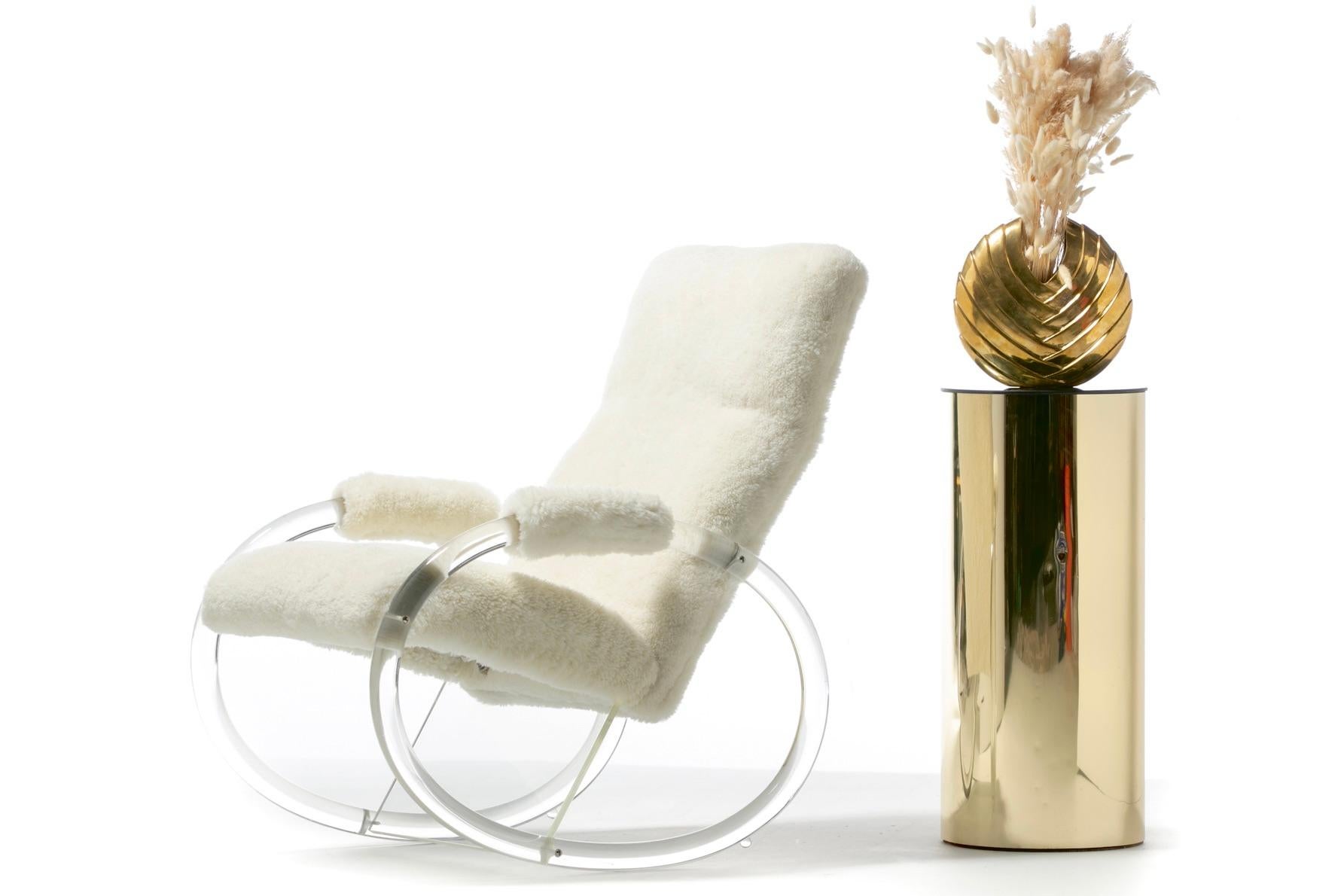 Galleggia su una nuvola con questo dondolo in lucite e shearling bianco in stile Charles Hollis Jones prodotto da Hill Manufacturing. Elegante. Comodo. Accogliente. La combinazione di lucite e shearling bianco conferisce a questa sedia a dondolo in