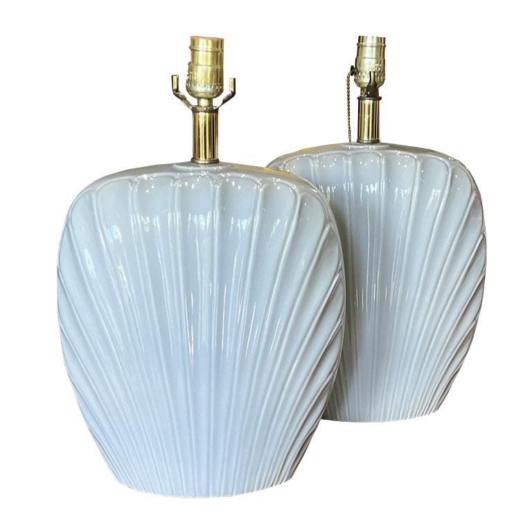 A pair of post-modern ceramic table lamps in a shell motif. This pair of lamps will add just the right touch of postmodern to any room. Each lamp is tall and features a pull chain to switch the light on and off. The body of each are tall and shaped
