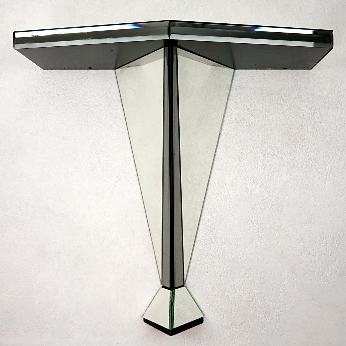 This console or side table has a remarkable presence due to the fact that it mostly consists of mirrored glass. It embellishes every object displayed on it by doubling its images and reflecting the light on it in a magical manner. The black edges
