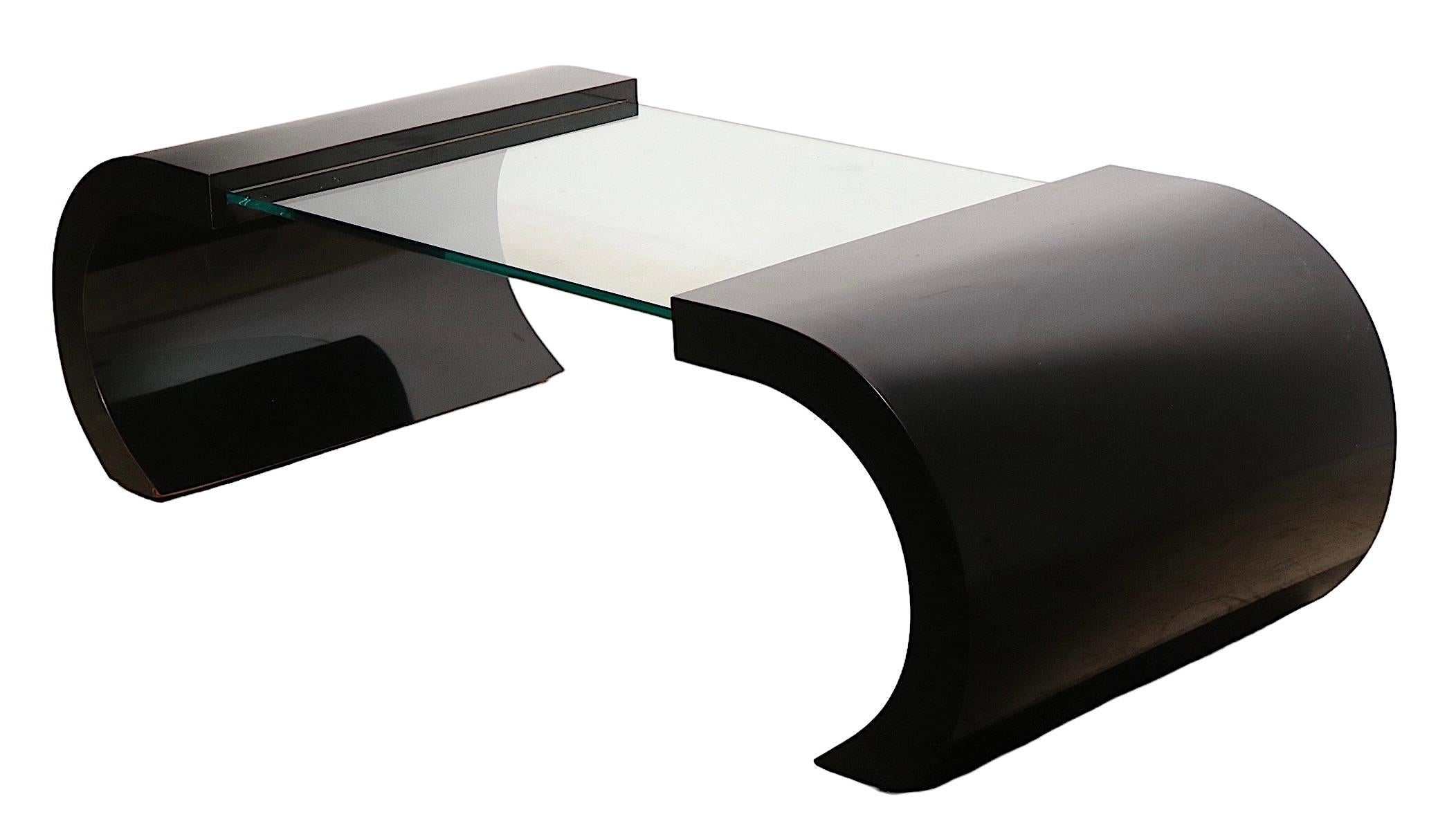 Post Modern coffee, or cocktail, table having dramatic C shaped black formica ends which support the thick ( .50 in. ) plate glass center panel.
 Design reminiscent of Verner Panton, made in USA, unsigned. 
 Total Dimensions:
 W 55 x D 24 x H