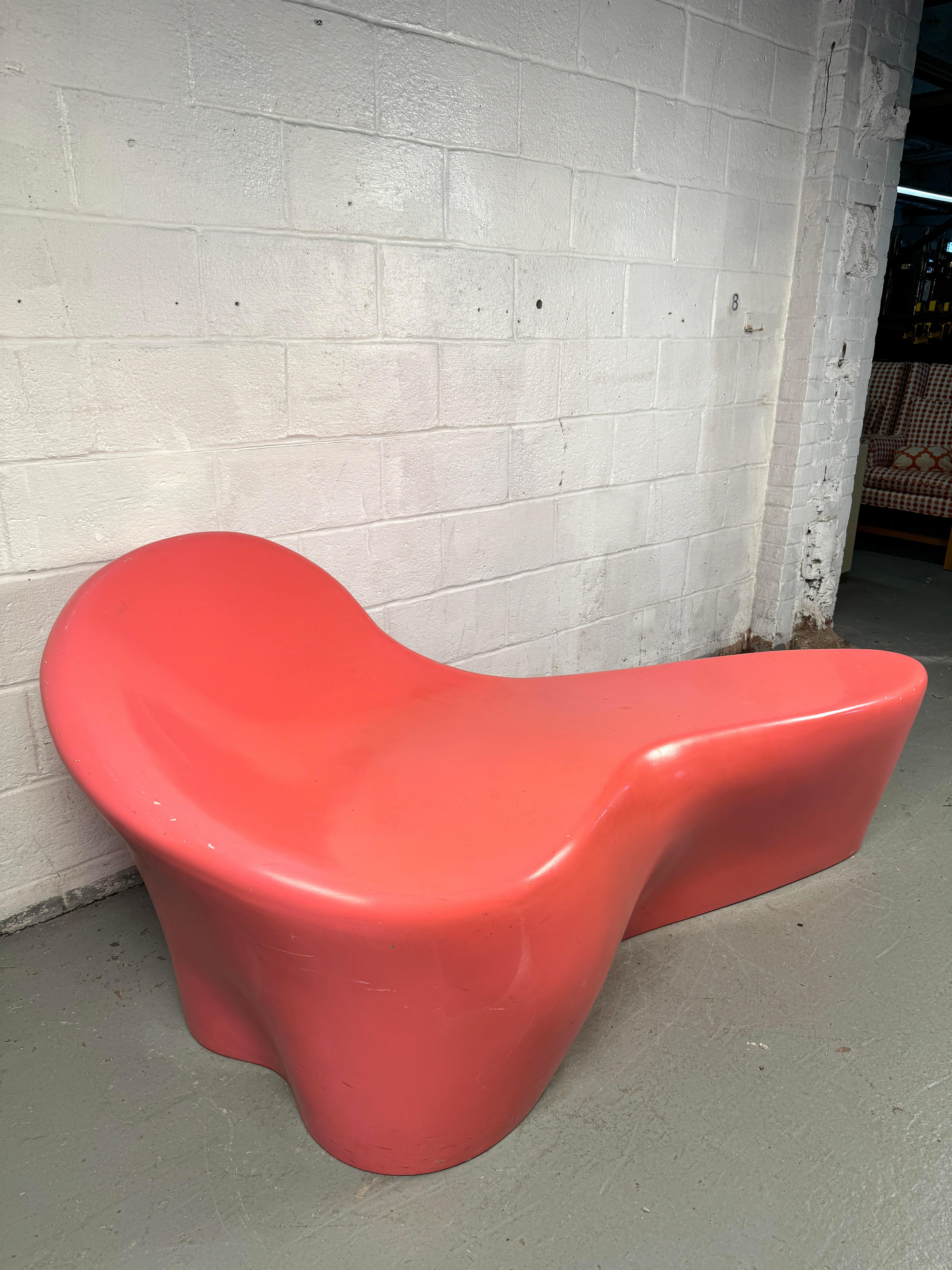 Ce banc en forme d'amibe est une pièce audacieuse et ludique, fabriquée en fibre de verre moulée et finie dans une teinte rose saisissante. Sa forme organique et sculpturale évoque le design post-moderne et de l'ère spatiale, ce qui en fait un