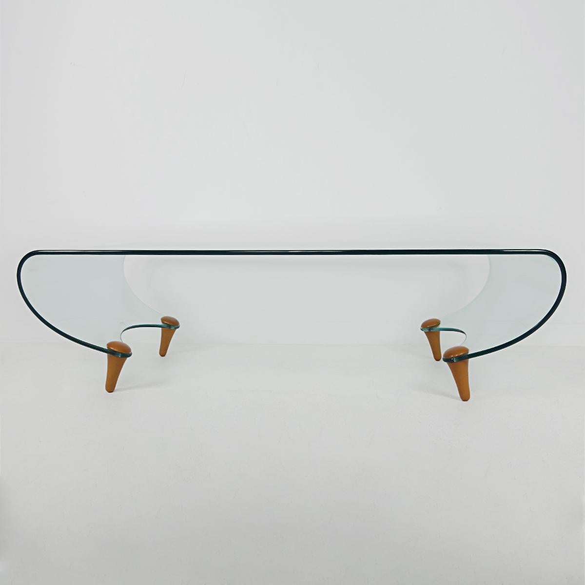 Rare coffee table Tango was designed in 1996 by Fabio di Bartolomei for Italian glass specialist Fiam Italia. The table has a glass top surface combined with four wooden legs. 
No longer in production. Signed in the glass: AB IH.
This coffee table