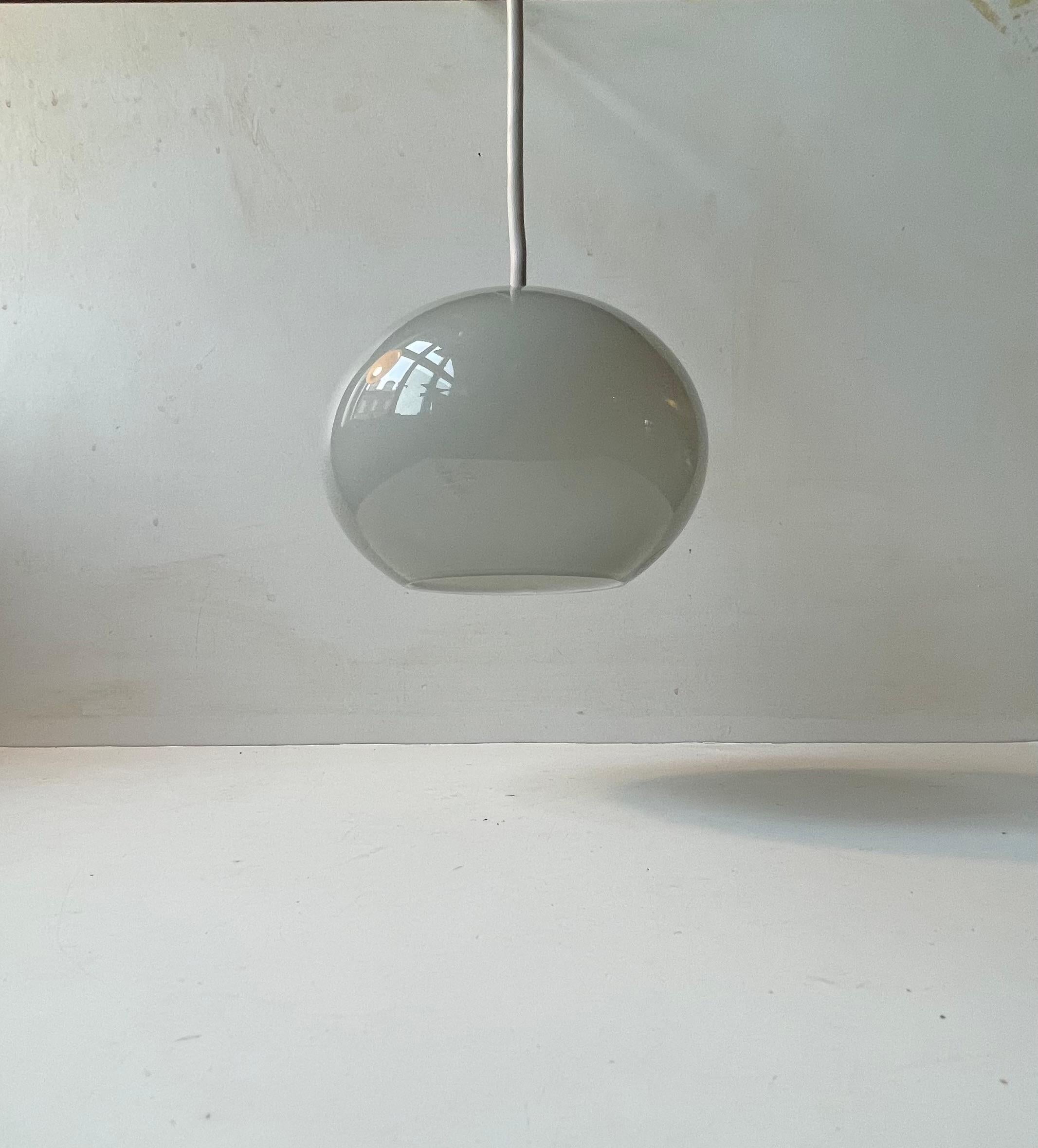 A small mouth blown mushroom shaped opaline and colored grey glass pendant light designed by Peter Svarrer and made by Holmegaard in Denmark during the early 2000s. Original sticker attached to the outside. Working order. Measurements: H: 11 cm,