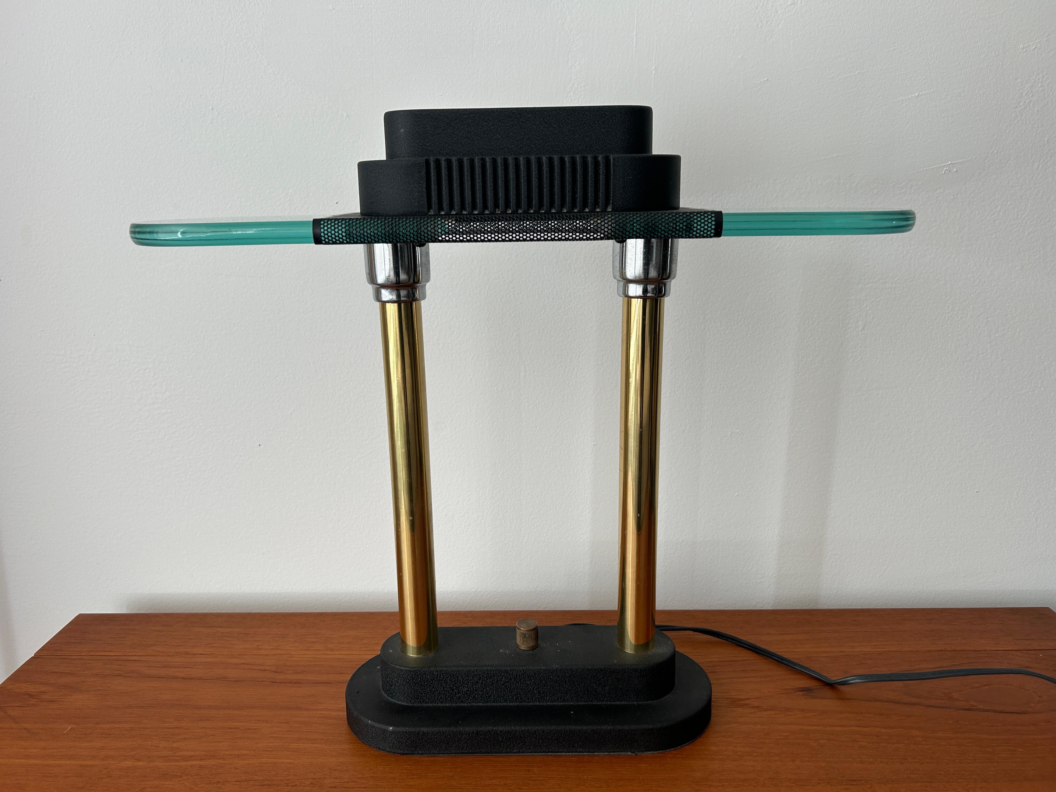 Lampe de bureau halogène au design postmoderne d'après Robert Sonneman pour Kovacs. S'utilise avec une ampoule halogène de 60 watts maximum. Variateur d'intensité avec bouton au centre de la base.  

Dimensions : H 15,25 x L 17,5 x P 4,75 in : H