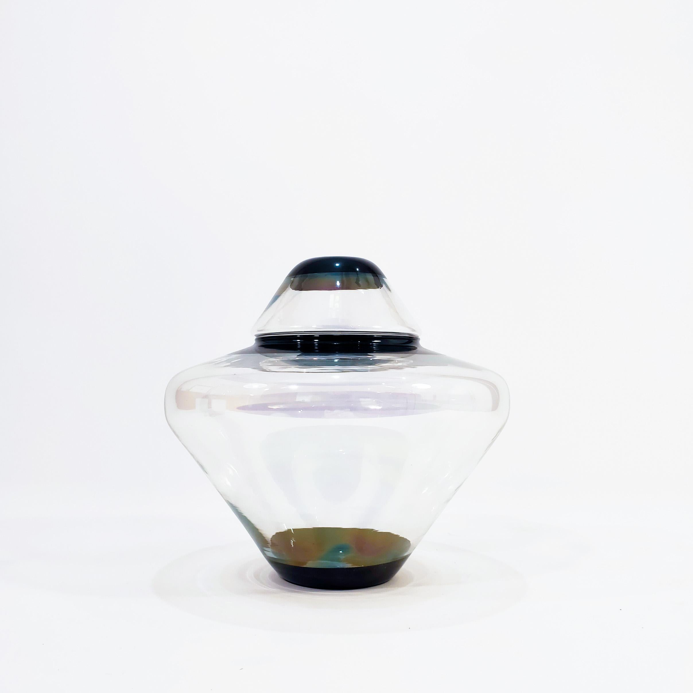 Iridiscent glass tibor from the 80s produced by La Mediterranea. The base and lid of this piece are made of slightly iridescent transparent hand-blown glass, with black trims. Very light and minimalist piece, with simple lines and so timeless. Very