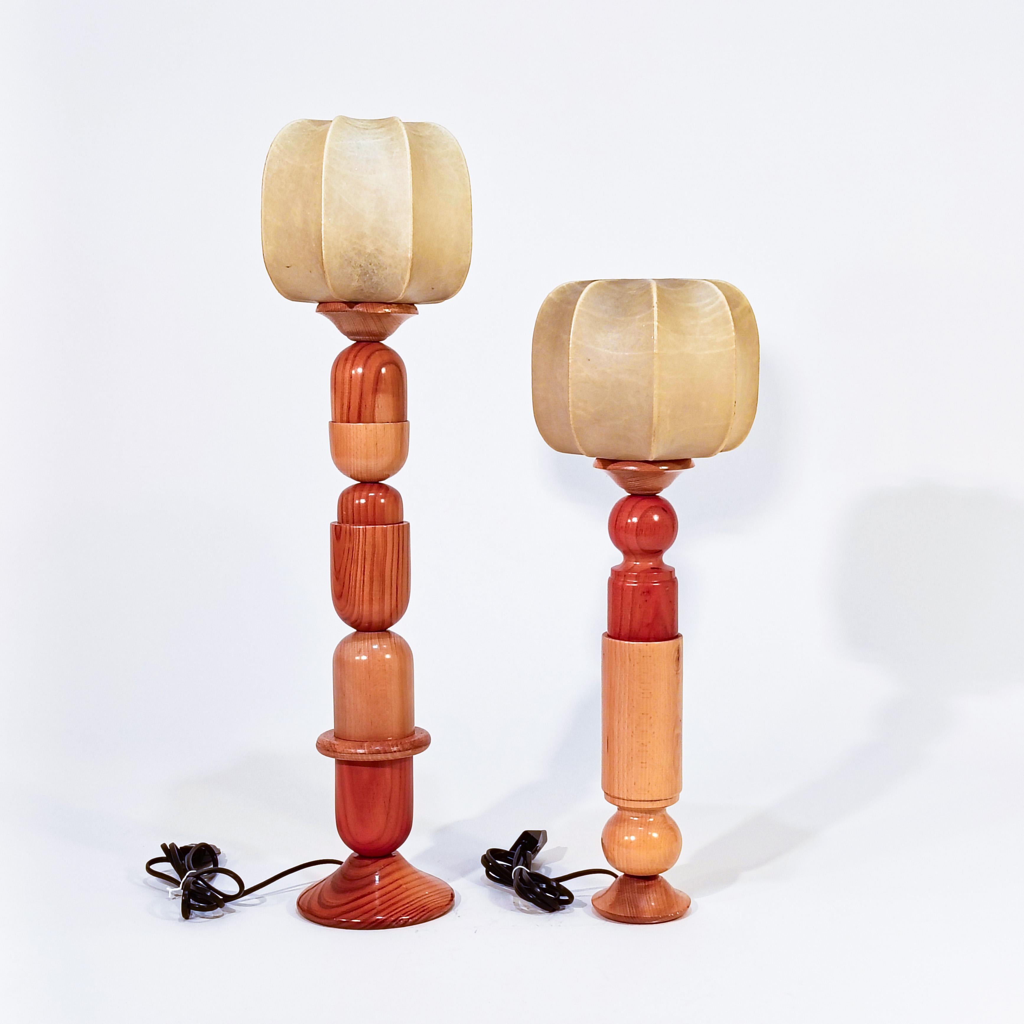 Pair of sculptural hand-crafted cocoon table lamps, Italy, 1970s. Formed by several varnished pine wood elements of different shapes and sizes, creating two curious columns of a certain Memphis and Brutalist style. Both columns culminate with two
