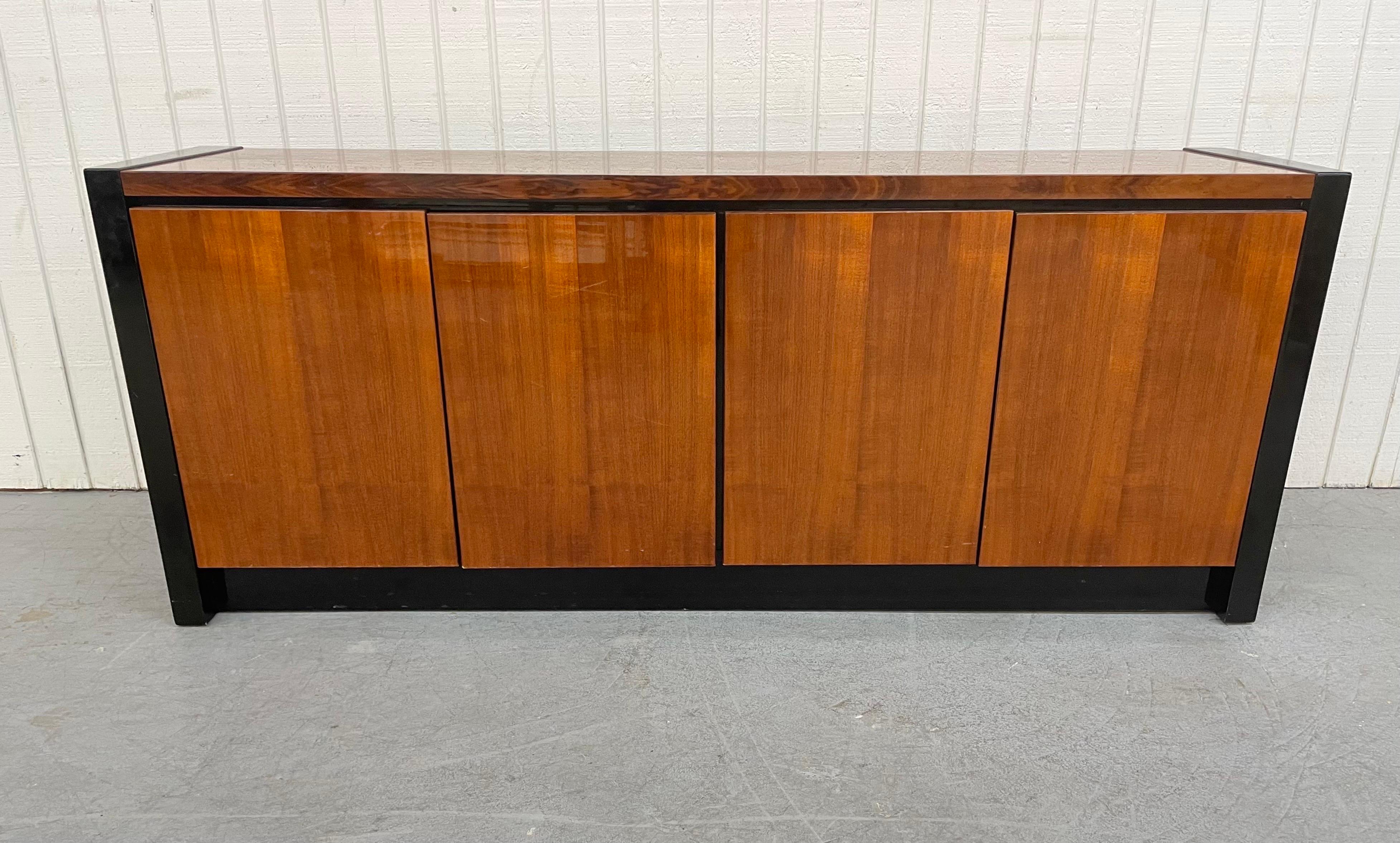 This listing is for a Post-Modern Henredon Lacquered Sideboard. Featuring a straight lined rectangular design, black lacquered sides, base, and interior, two doors on the left that open up to three drawers, two doors on the right that open up to a