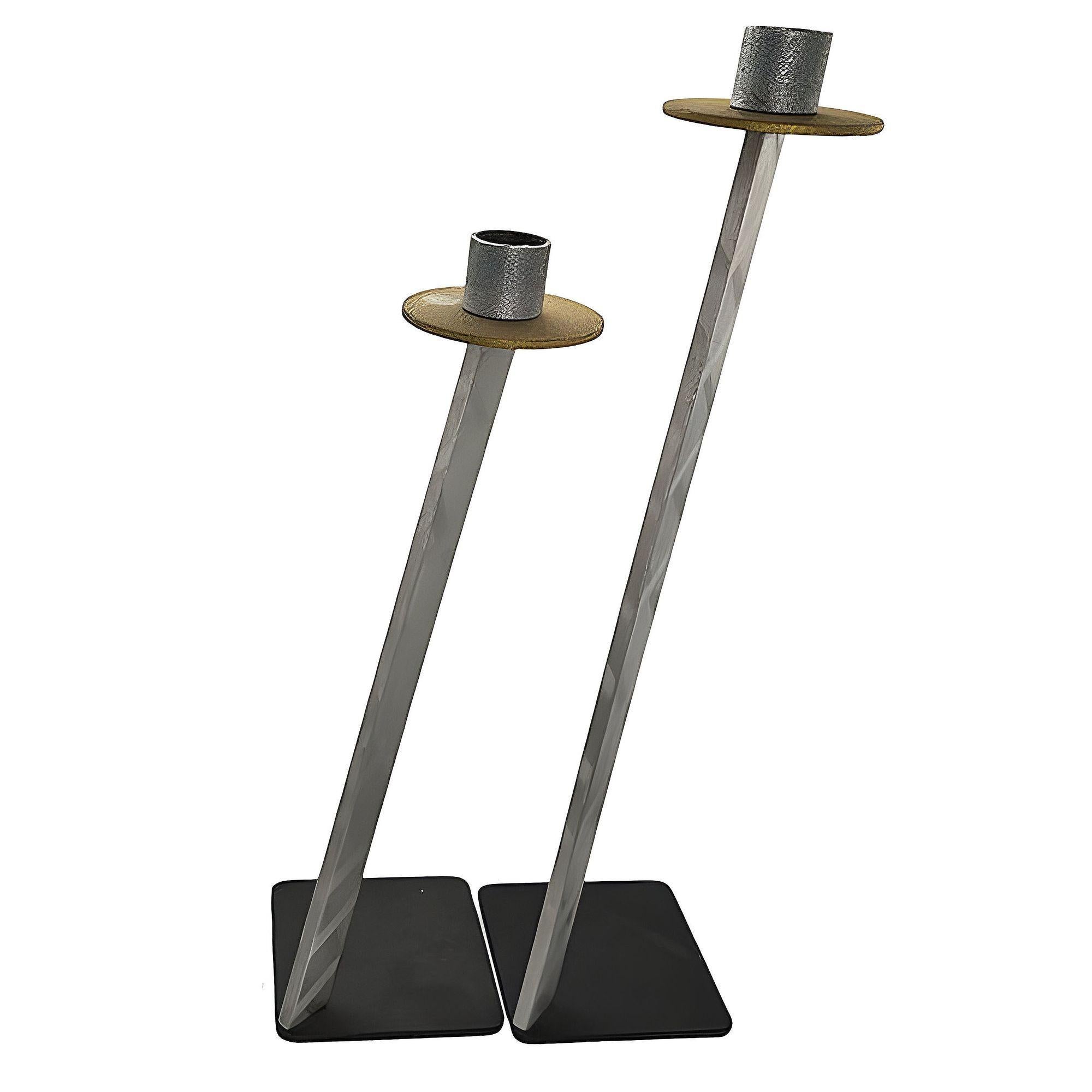 Bruce R. MacDonald's signed set of two large candlestick holders made from a black anodized steel base, polished steel neck, and bronze decorated holder. The two candle sticks form a stepped pattern creating a dynamic visual display when arranged