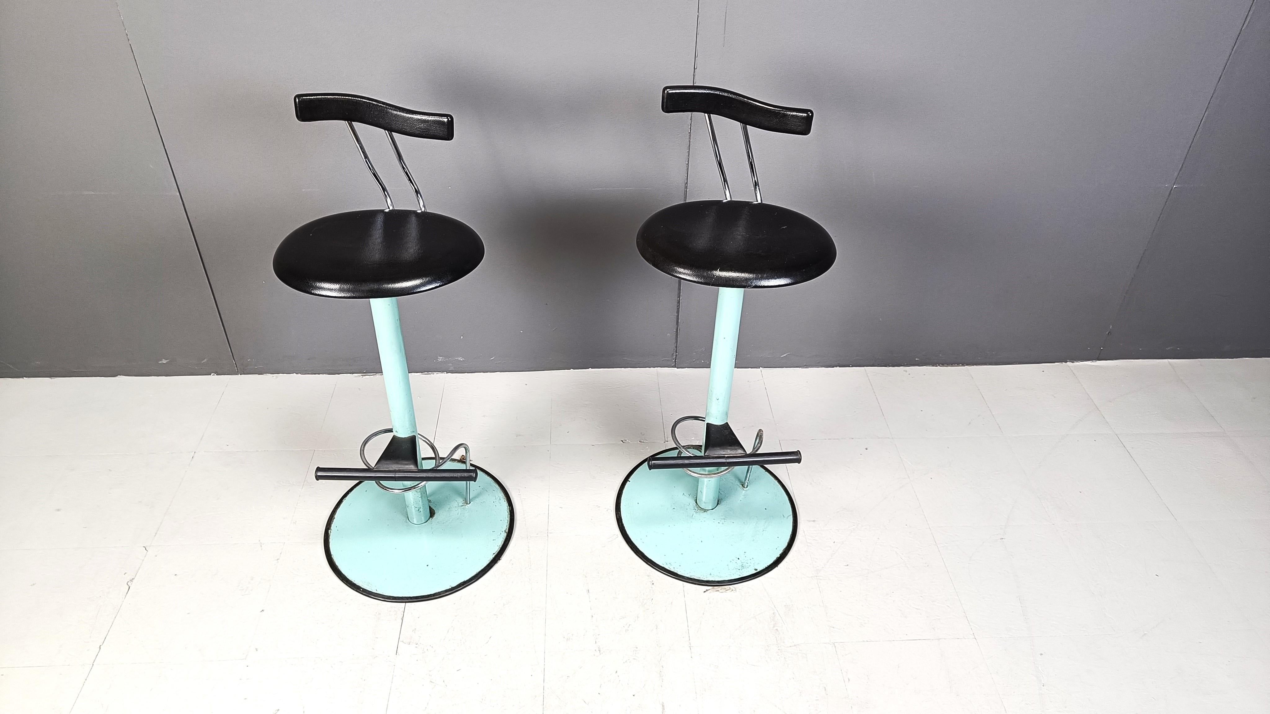 Striking post modern dining chairs with green metal bases and black leatherette upholstery.

Very cool and playful design.

1980s - Italy

Good overal condition with normal age related wear.

Dimensions:
Height: 97cm
Width x depth: 44cm
Seat height: