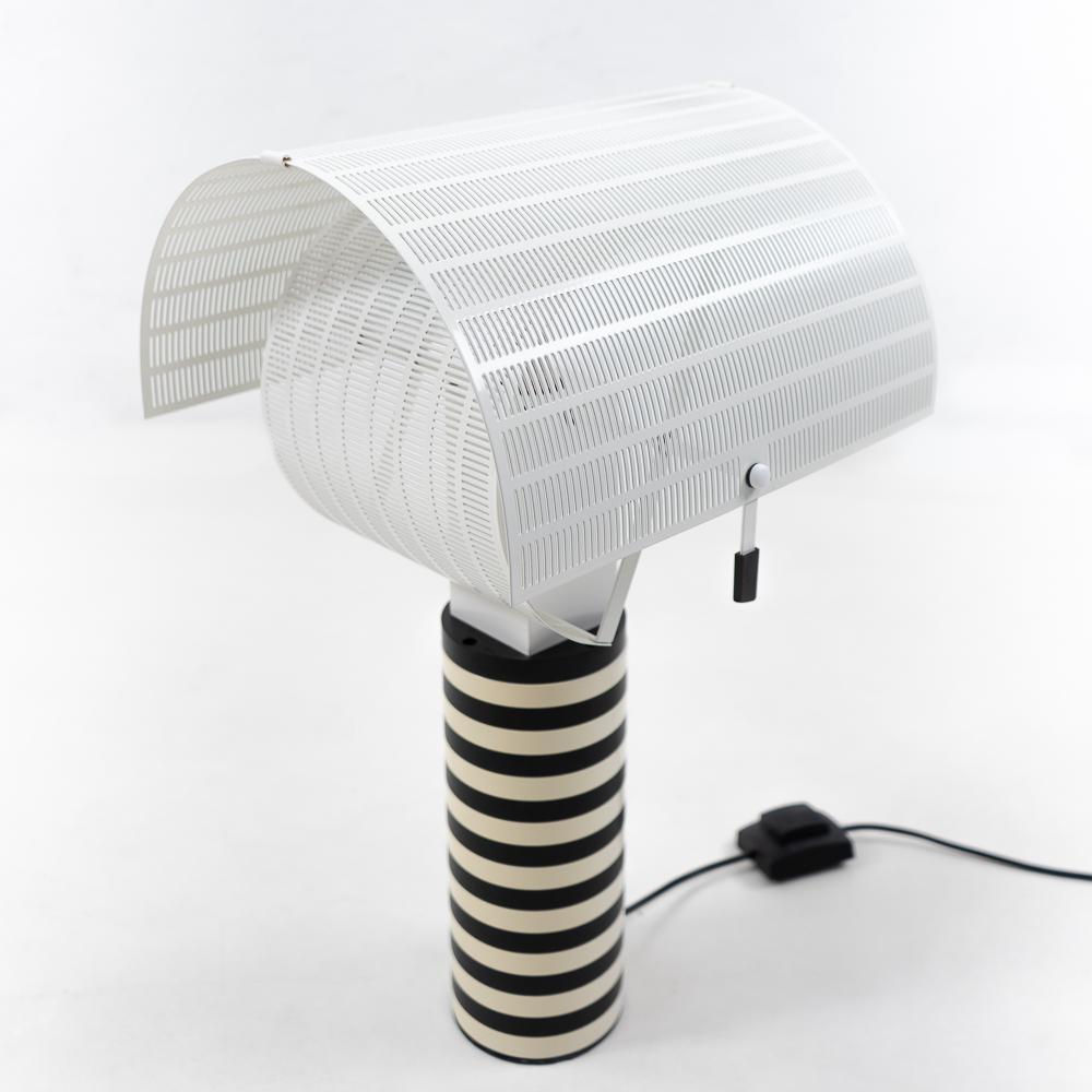 Vintage Artemide table lamp, model Shogun – a design by the architect Mario Botta (1985).

An impressive lamp being a typical design originating from the Memphis-Milano movement.

Materials: Powder coated cast-iron base. The metal cylindrical