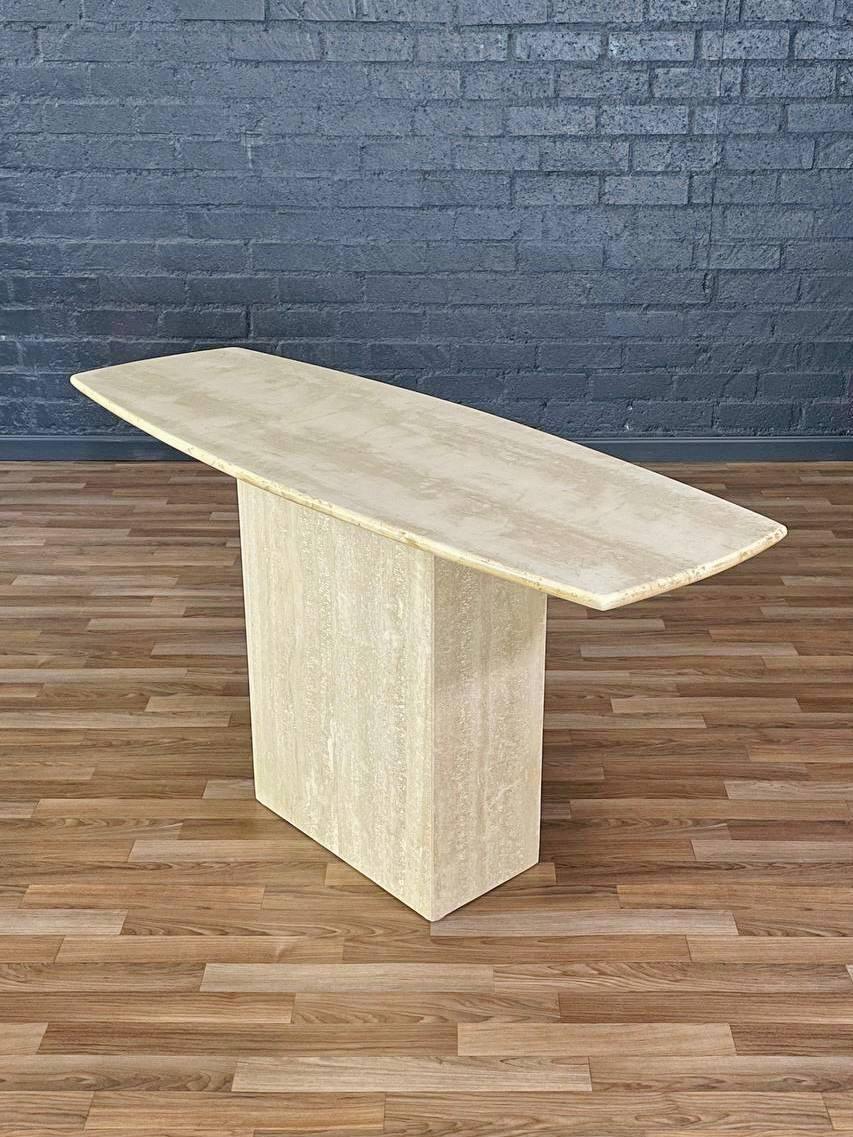 Condition: Original Vintage Condition  

Crafted in Italy during the 1980s, this Post Modern console table features clean, architectural lines in natural travertine. The elongated top rests on a monolithic base, creating a balanced and sculptural