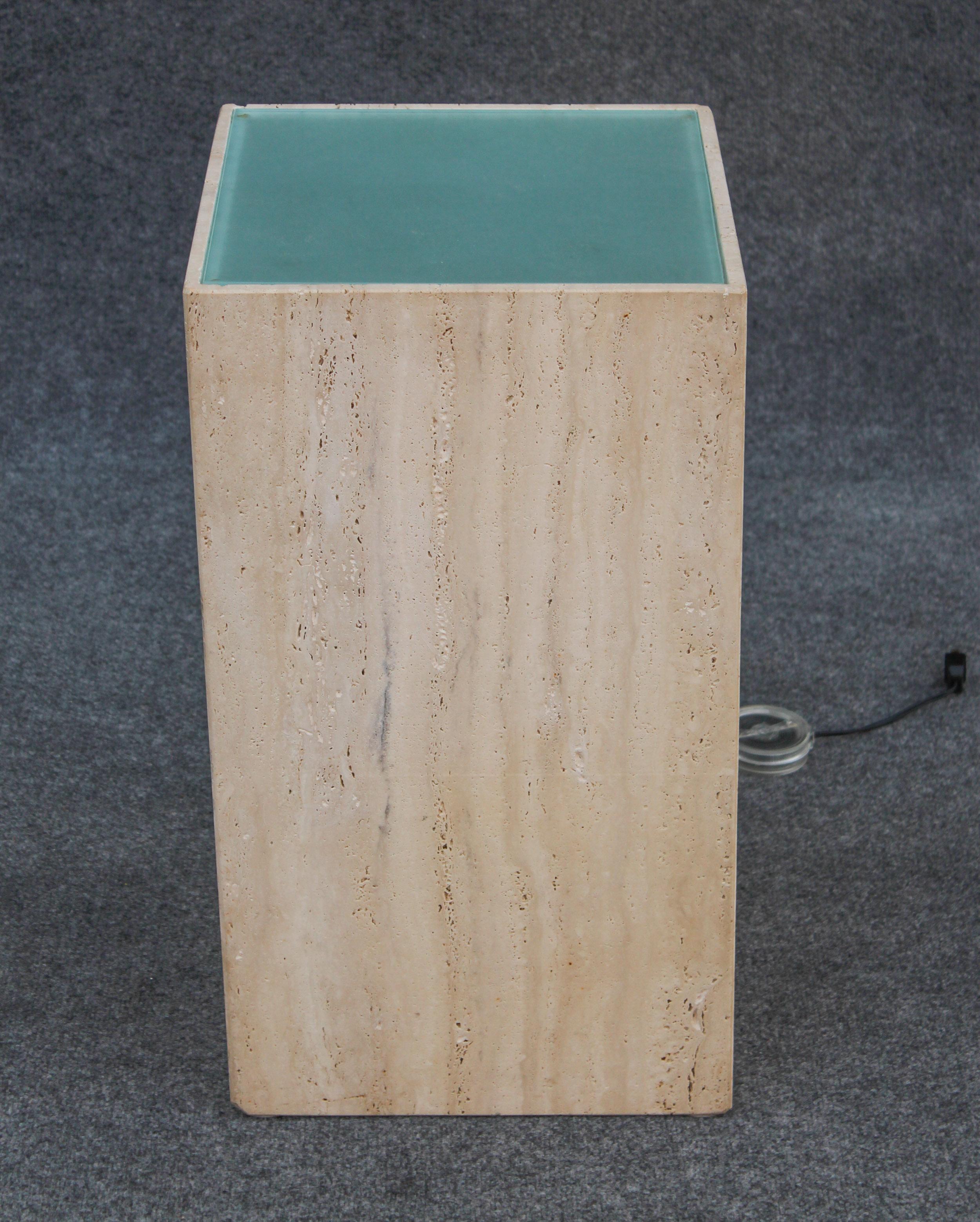 Simple, sleek, elegant and well-made - an illuminated travertine-marble pedestal. This pedestal was made in Italy in the mid to late 1970s and imported into the US thereafter. Features a handsome tinted frosted glass top and retracting wire for