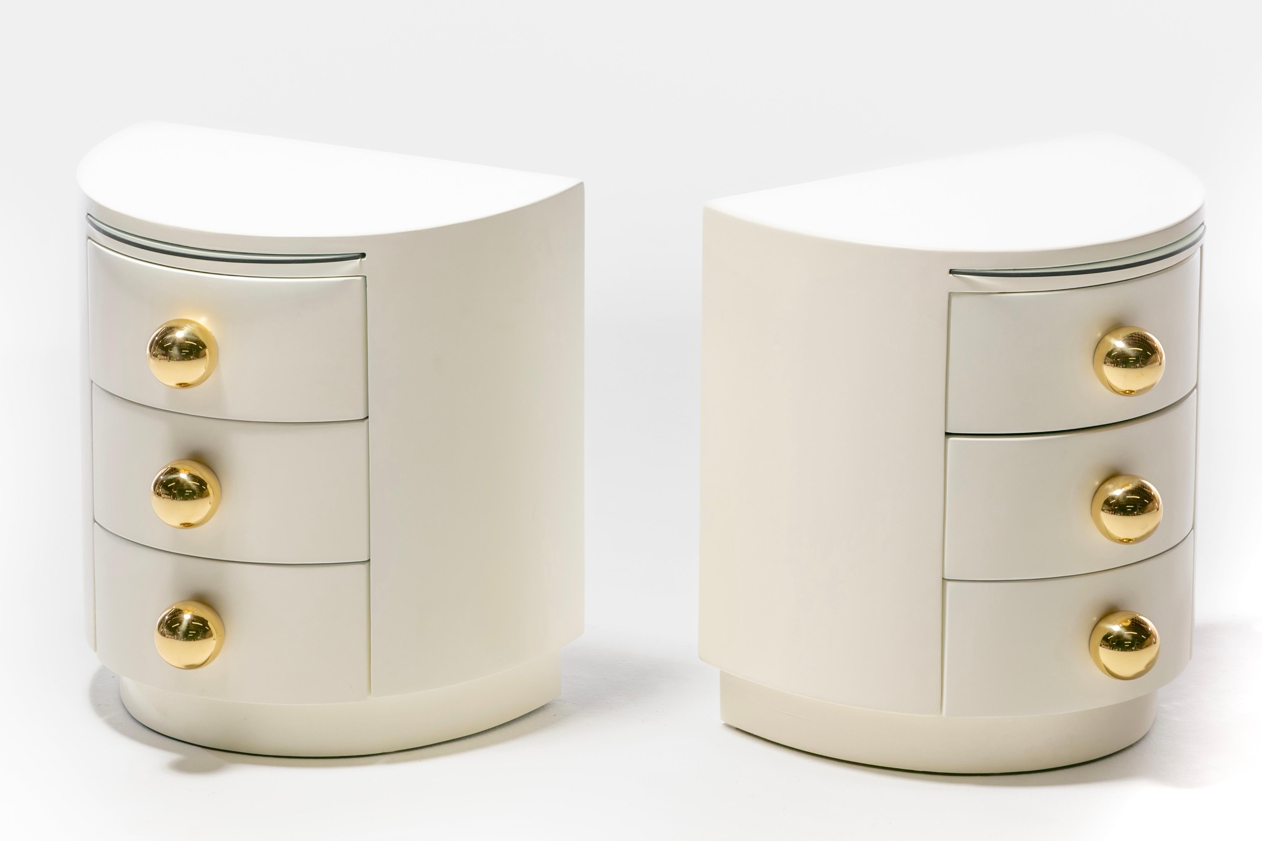 Sexy pair of fully restored from top to bottom Post Modern Night Stands newly refinished in ivory lacquer with professionally polished oversized spherical brass hardware. Modern. Clean. Understated elegance. It's hard to believe these nightstands