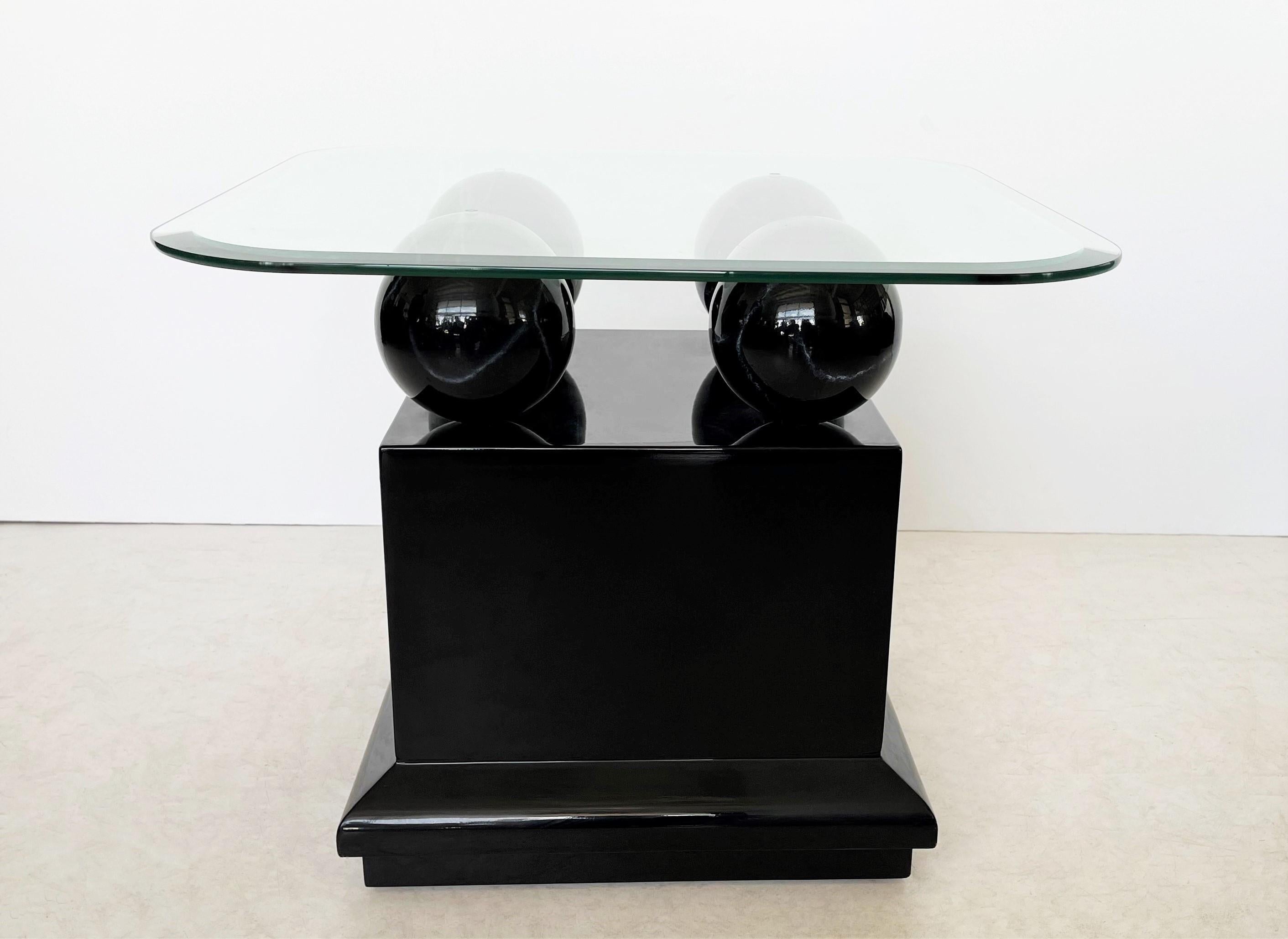 Postmodern styling stunning from every angle these side or end tables designed and created in the 1980s. Freshly black lacquered bases with four faux black marble spheres that support beveled glass tops with soft rounded edges. These will easily fit