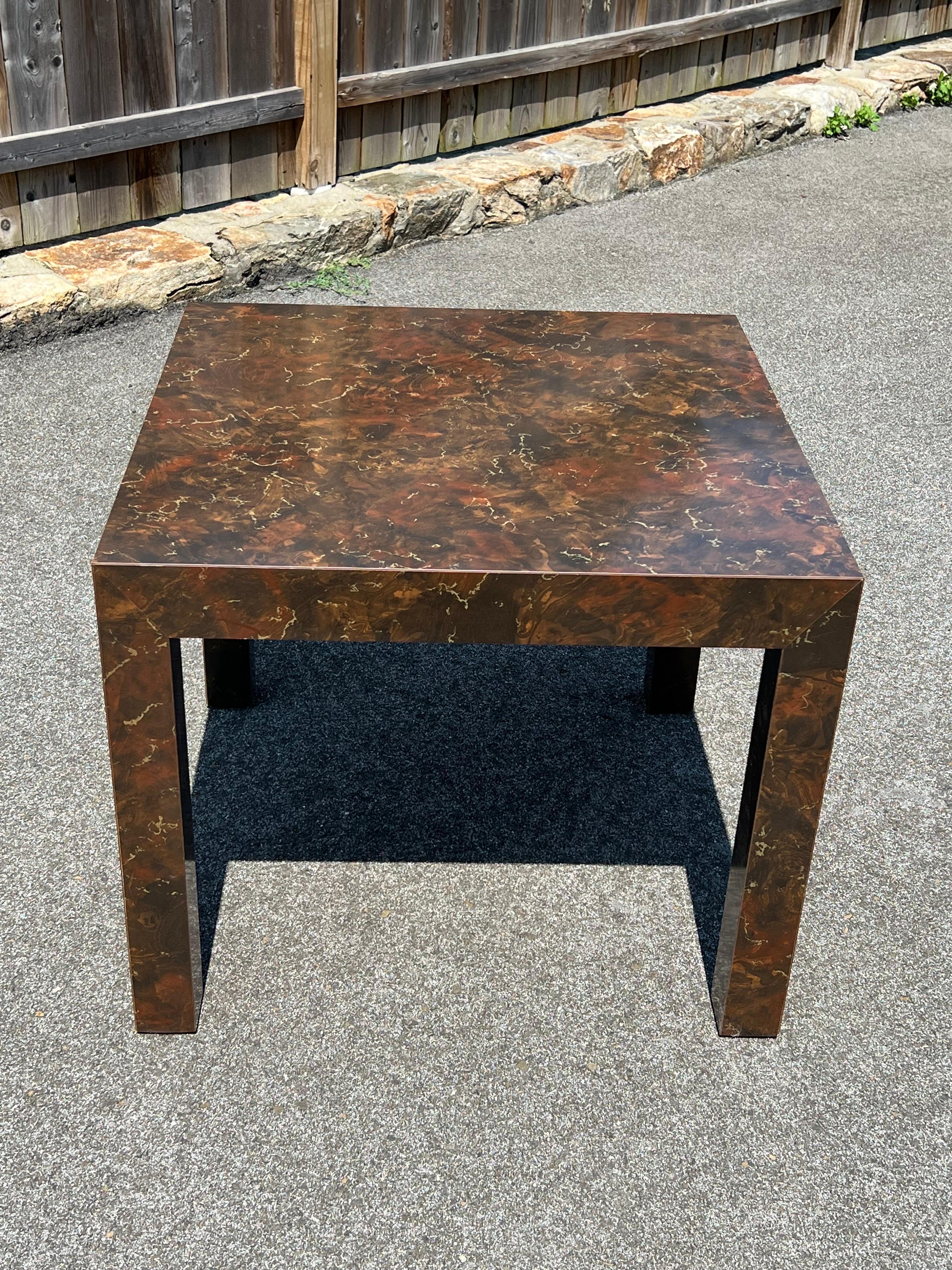 Post Modern Laminate Tortoiseshell End Table. Square table with earth tones of brown, gold and orange. Nice oversized size for a square space. This item can parcel ship economically. Matching sofa table, end table and coffee table are also available.