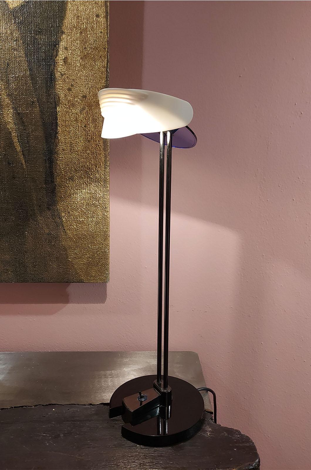 Post Modern Camp lamp designed by Perry King for Arteluce in 1980. The lamp features a white, adjustable plastic shade attached to a blue plastic base. The on and off switch is on the base. The lamp is made of plastic and the central stem is made of