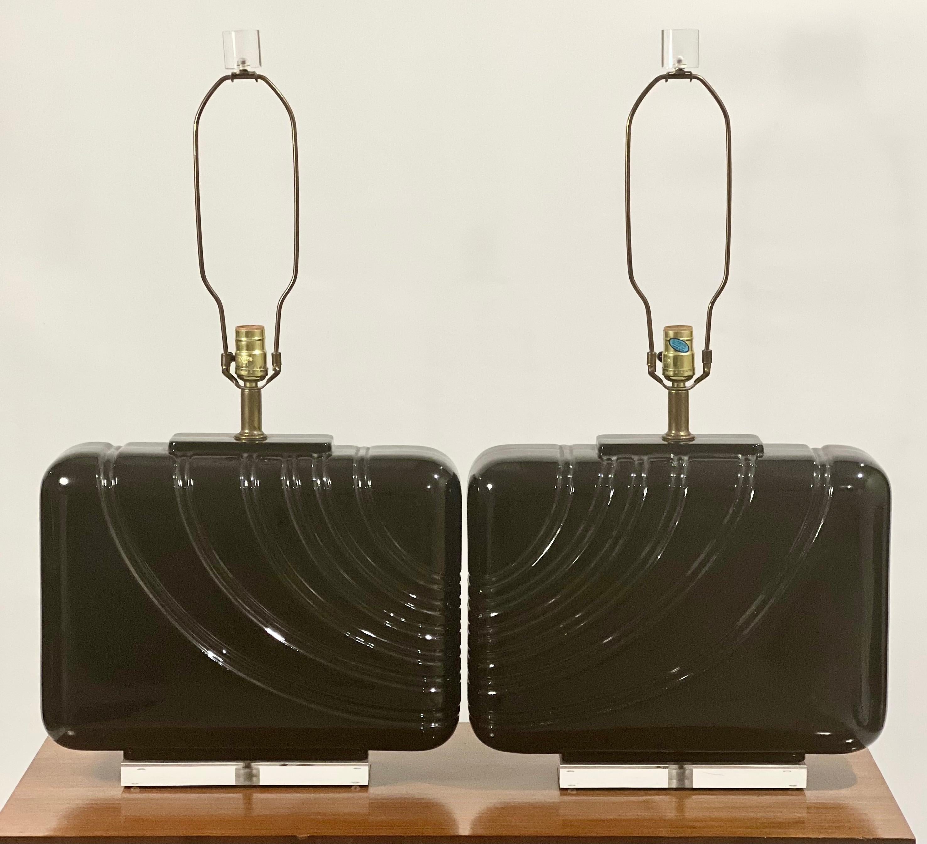 A gorgeous pair of oversized black glazed ceramic lamps from the 1980's.

Each lamp features a continual, channeled wave pattern on a rounded rectangular body with a lucite base and coordinating cylinder form finial. The glazed ceramic has a high