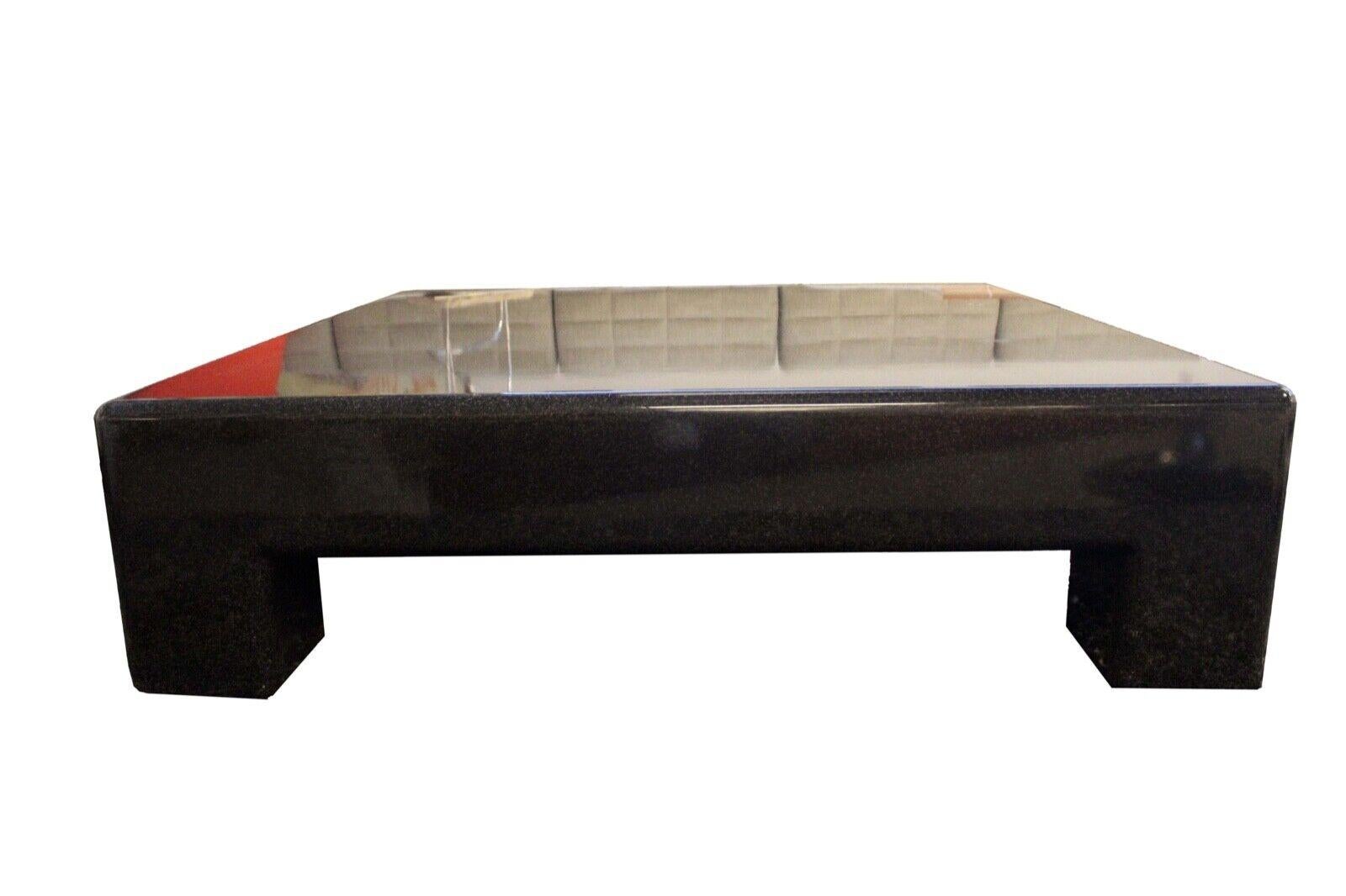 We present this extremely heavy and sturdy beautifully designed stone composite square large black coffee table. In excellent condition. Dimensions: 53.5