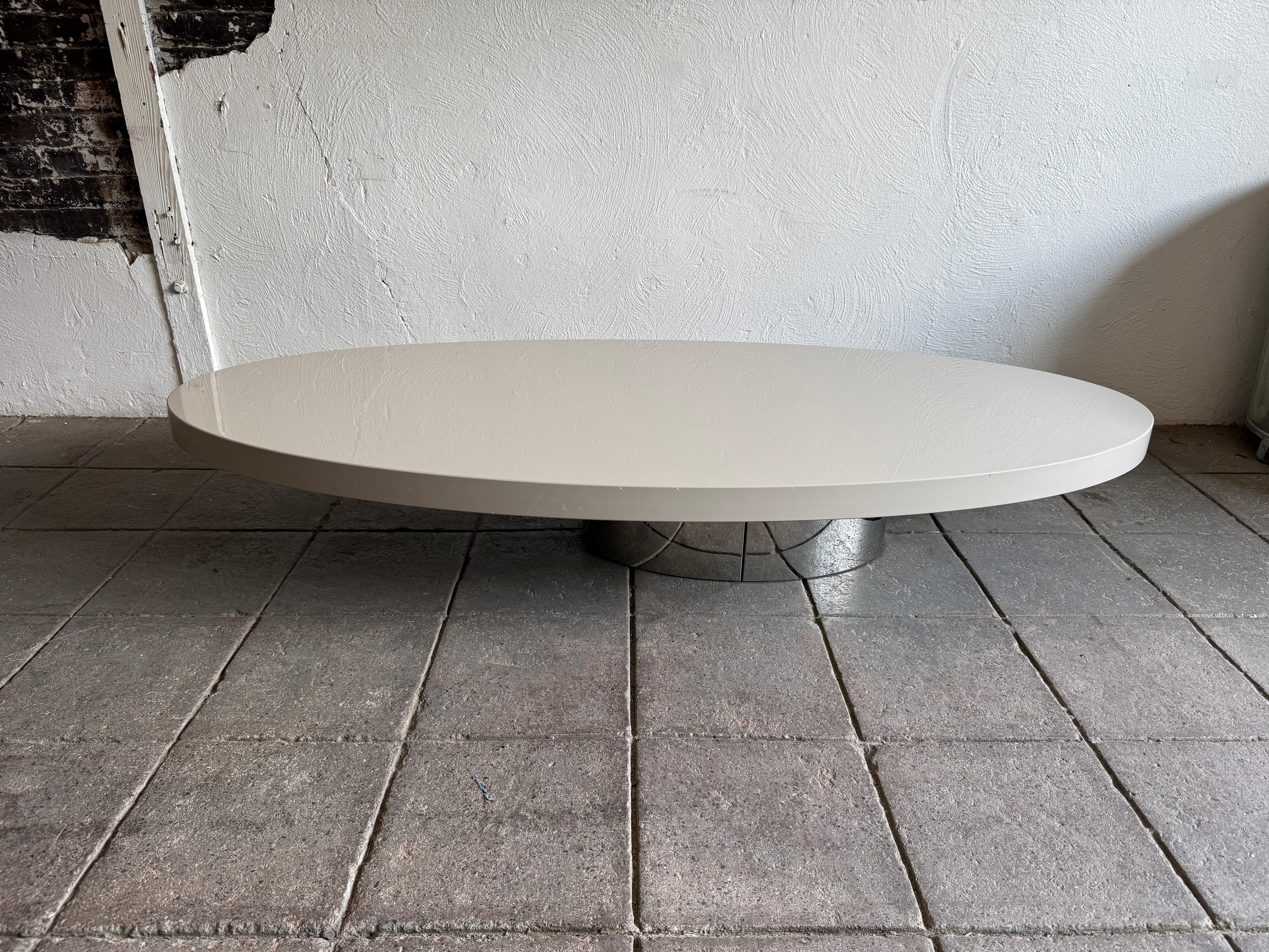Post modern low long oval taupe lacquer coffee table. Beautiful table with off center oval chrome weighted base. Very heavy and solid coffee table. Very nice light taupe gloss lacquer finish. Ready for use. Located in Brooklyn NYC.

Measures 69” x