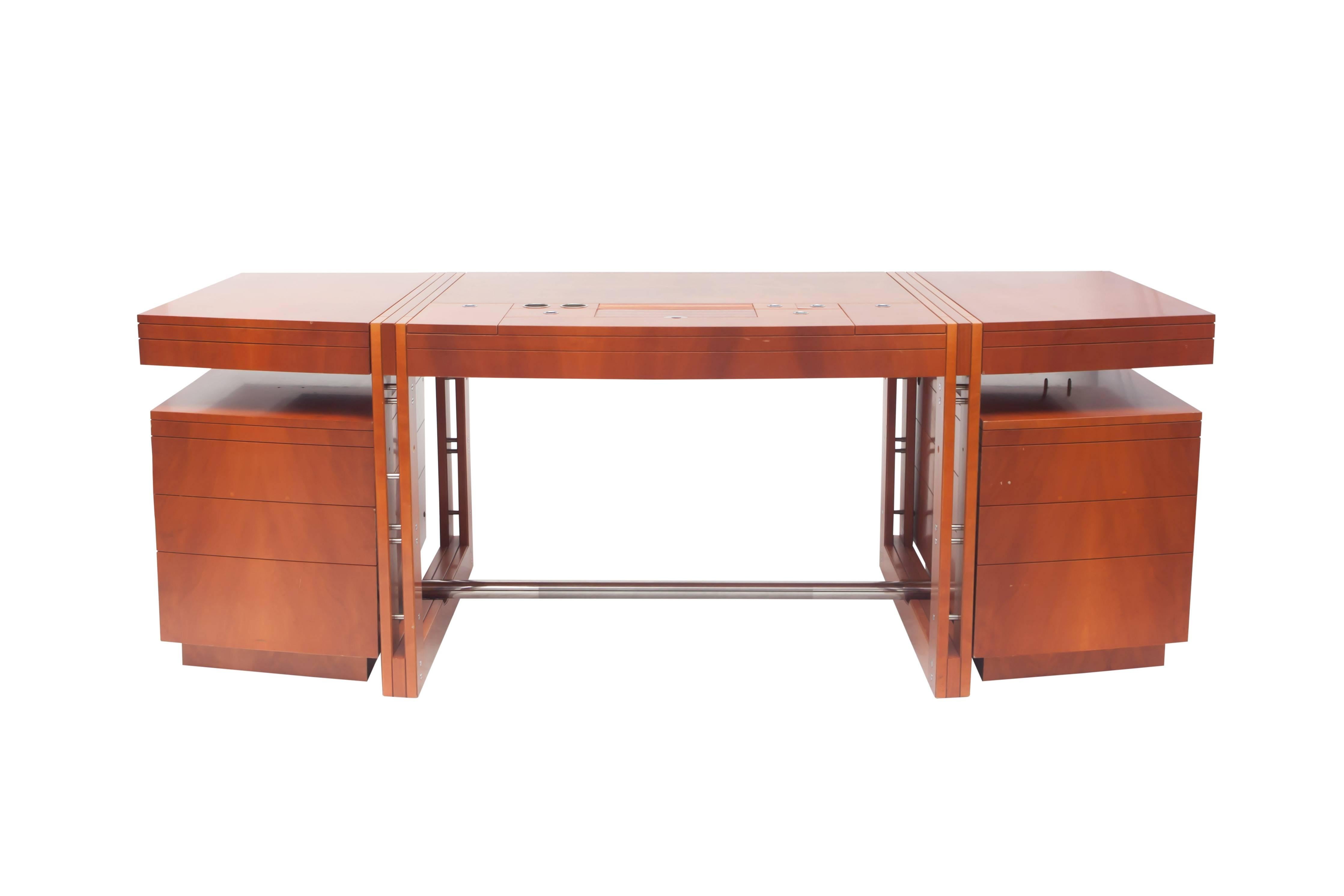 Post-modern High-end desk of the Tresserra collection.
It’s one of the most emblematic pieces of the collection, designed in 1988. 

This is an original model of the target desk.
Measures: L 210 cm x D 85 cm x H 74 cm.

Dark walnut wood.