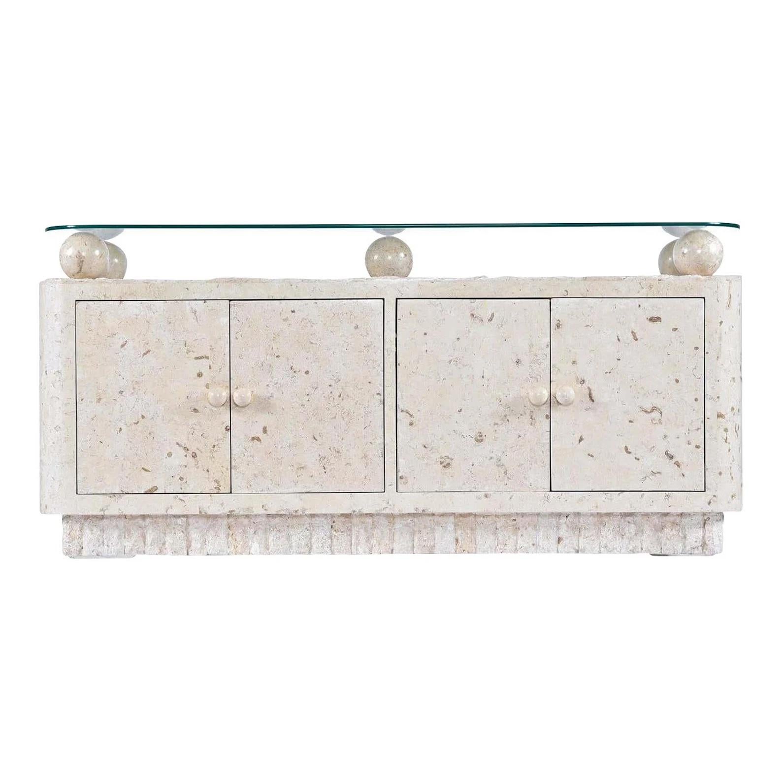 This tessellated Mactan stone credenza with curved edges features five smooth, tessellated stone orbs that sit under the tempered glass top.

Designed in the style of Maitland-Smith; attributed to Magnussen.

Mactan stone is a kind of white coral