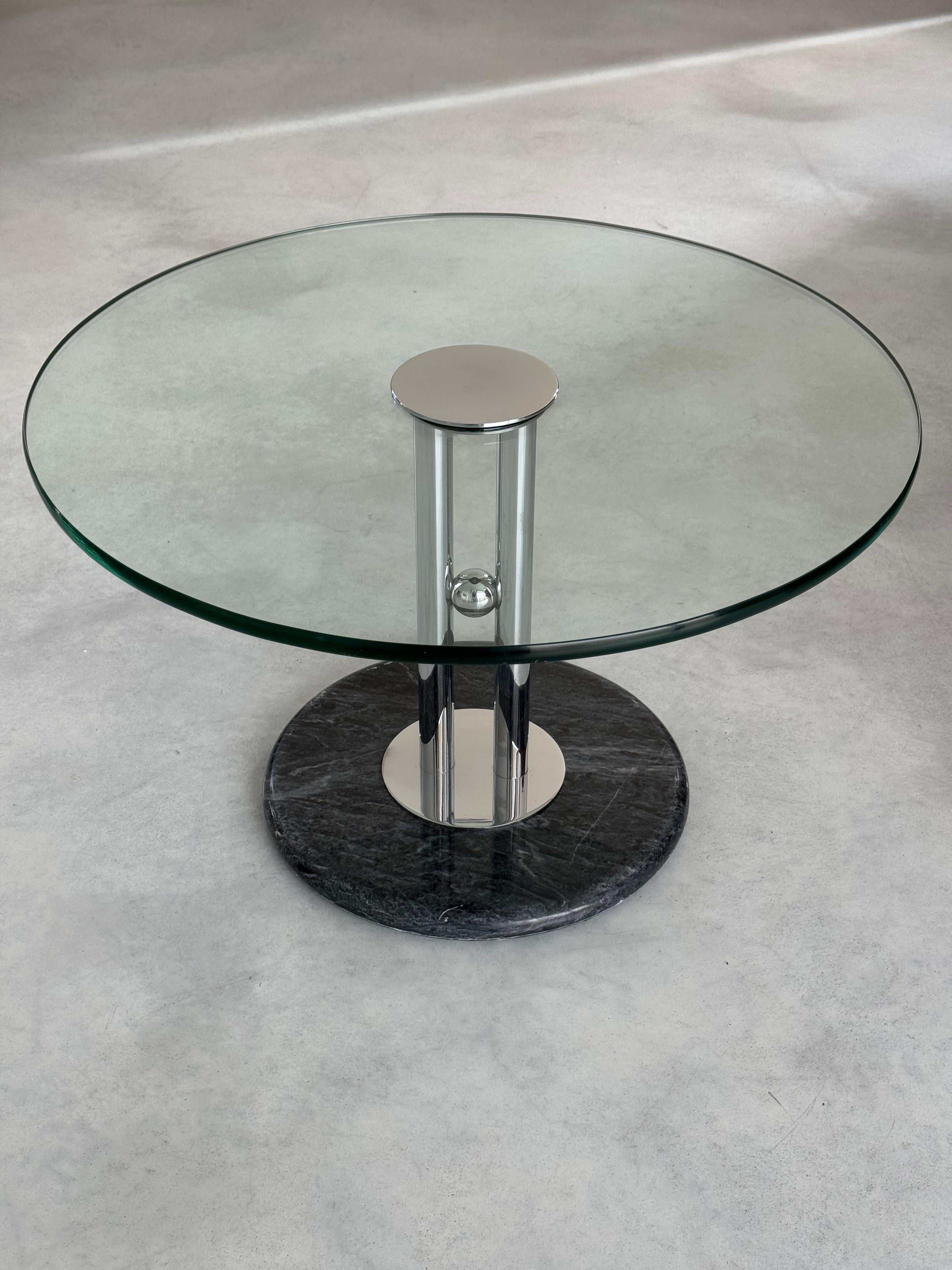 Post-Modern designer coffee table.
Marble base, chrome structure composed of two parallel cylinders and a sphere. Circular safety glass top (thickness 2.5 cm, diameter 65 cm).
The table is in good condition, traces of use and time spent.

Italian