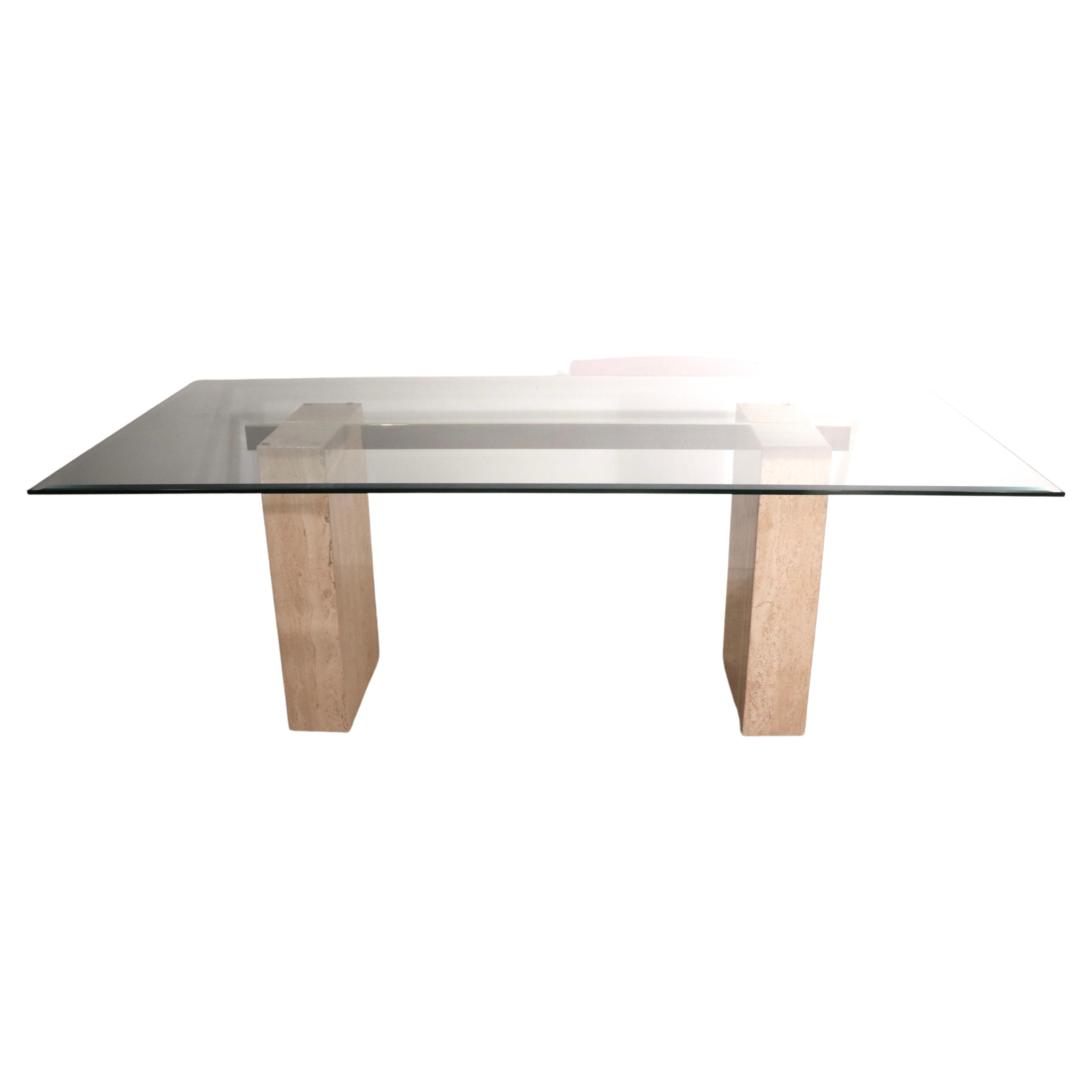 Chic, voguish, and sophisticated late 20th C large dining table by noted Italian furniture maker Artedi. The table features an impressive beveled plate glass top ( 78.25. x 39. 25 x 3/8 inch ) which rests on two marble pedestals, with a connecting