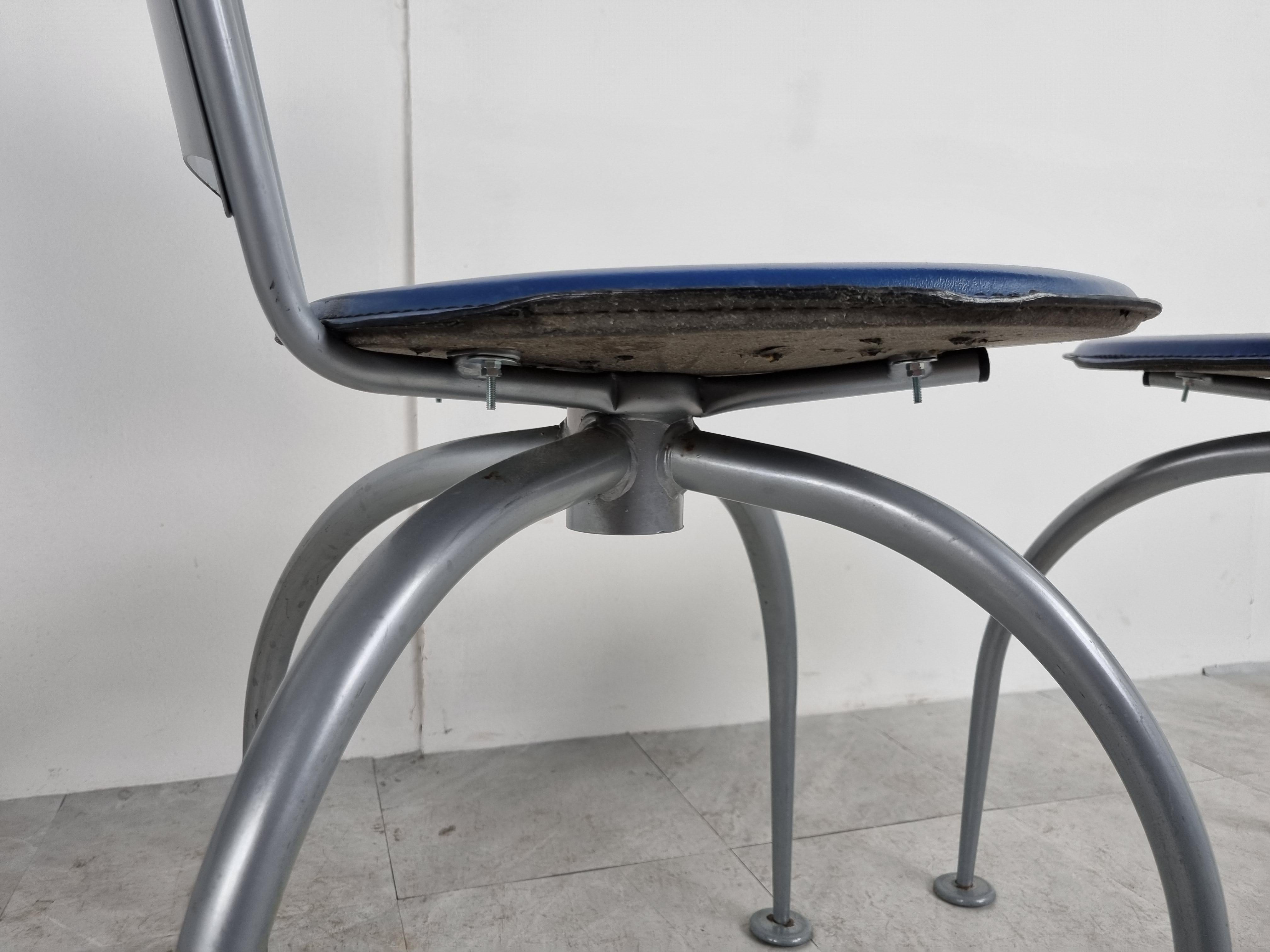 Unique design dining chairs with a nicely designed metal frame and blue imitaion leather seats.

The designer is unknown but we very much like the design style which was used here.

It has some Phlippe Starck vibes about it.

1990s - Probably
